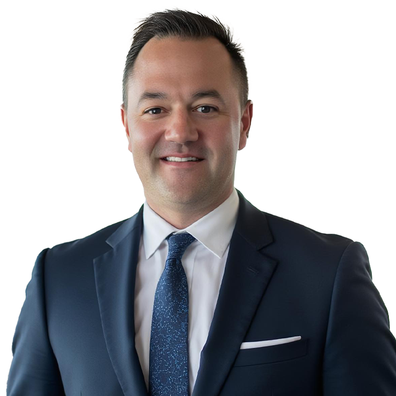 A professional man in a dark suit, white shirt, and blue tie, smiling at the camera.