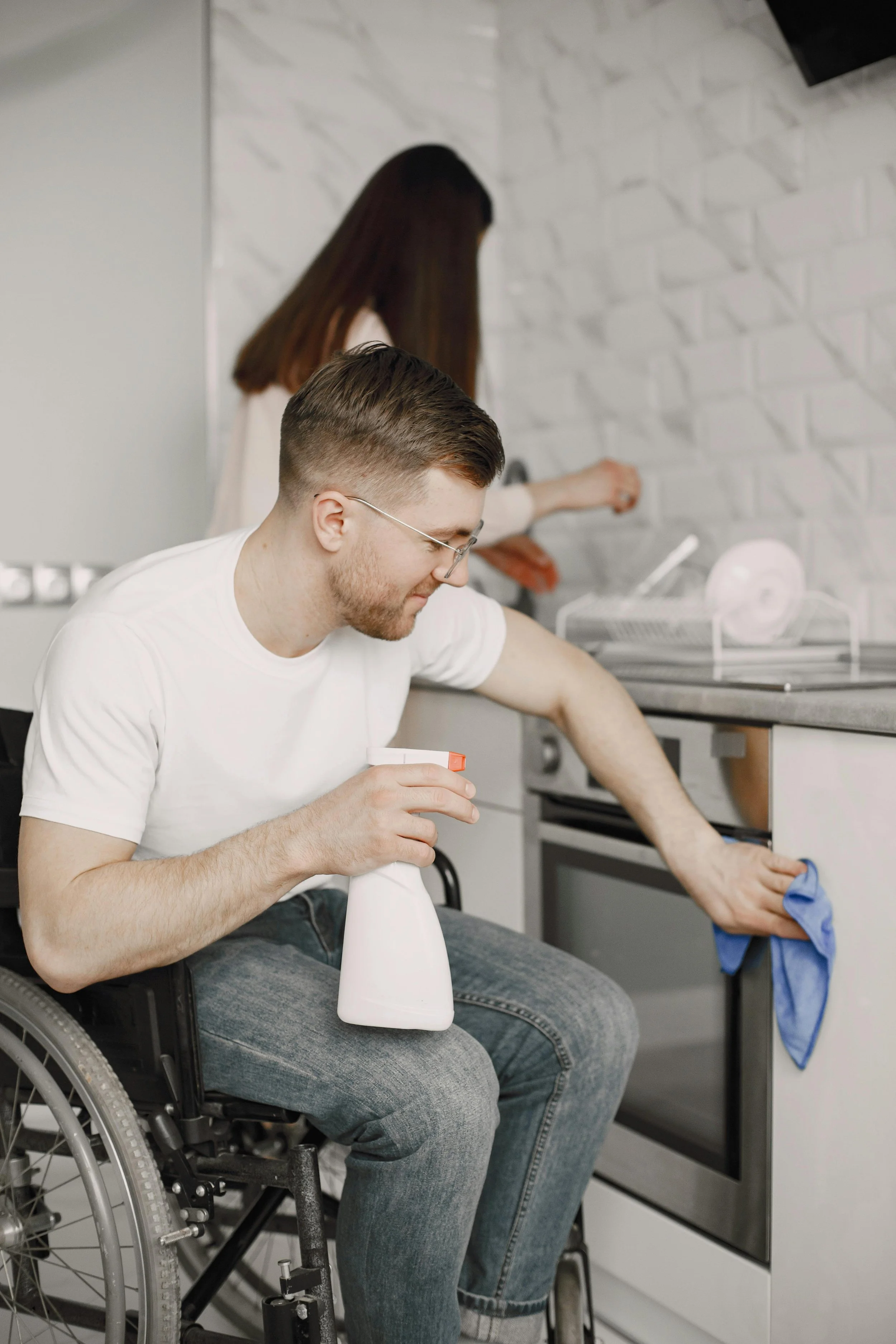 Young main in a wheelchair cleaning