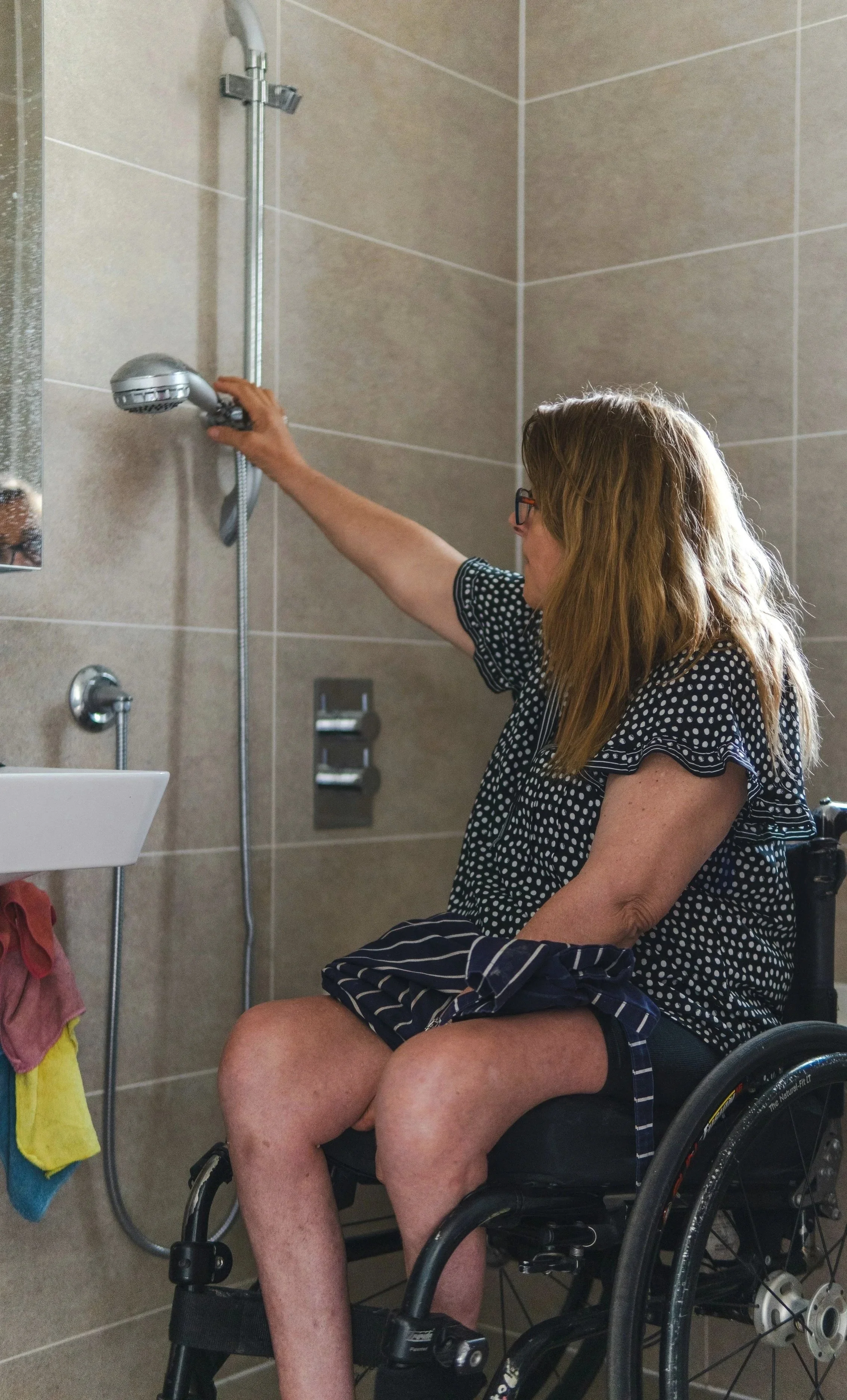 Women in the shower with a wheelchair.  Wet room adaptation