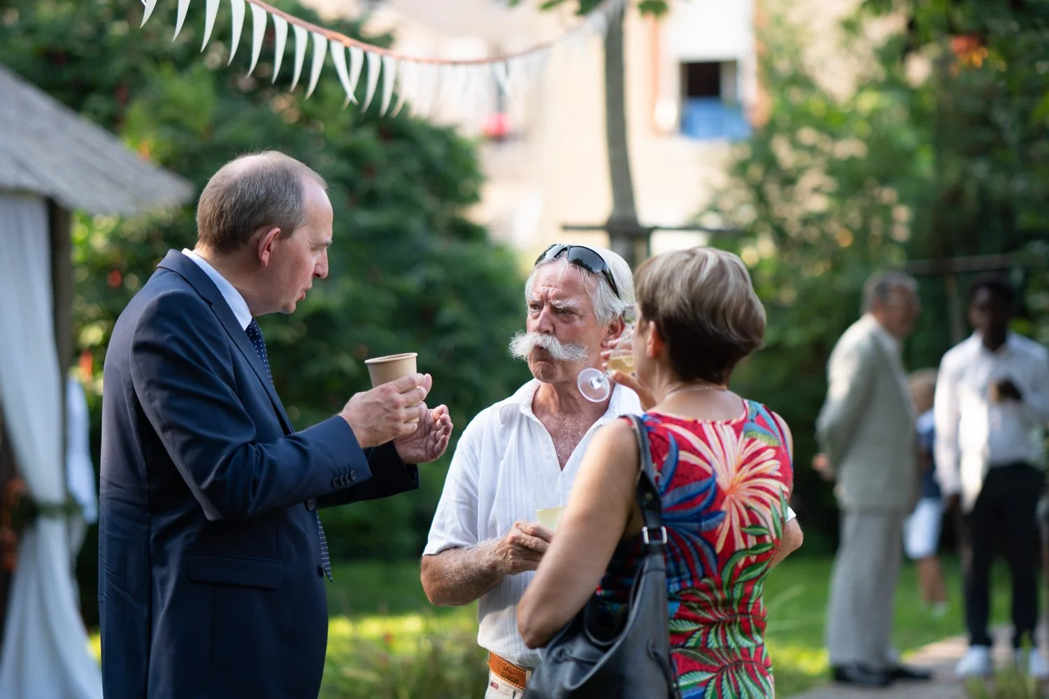 Les invités discutent durant le vin d'honneur à Lunéville. Par Viviane Eyer, Photographe de mariage dans le Grand Est.