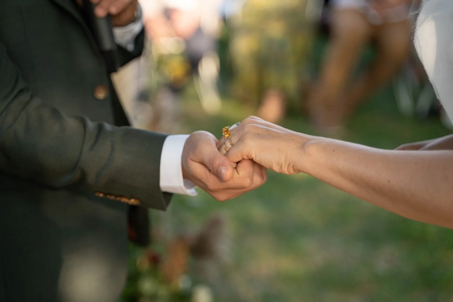 Détails lors d'un mariage en Lorraine, les mariés se tiennent tendrement la main. Par Viviane Eyer, Photographe de mariage dans le Grand Est.