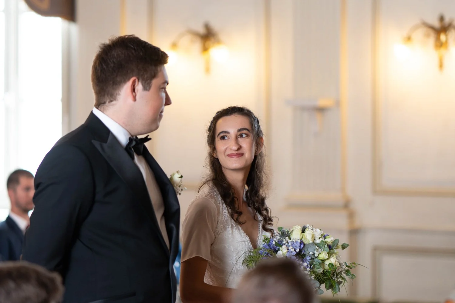 Deux mariés se regardent tendrement lors de leur cérémonie civile à la mairie. Lunéville - 2022. Par Viviane Eyer, photographe de mariage dans le Grand Est.