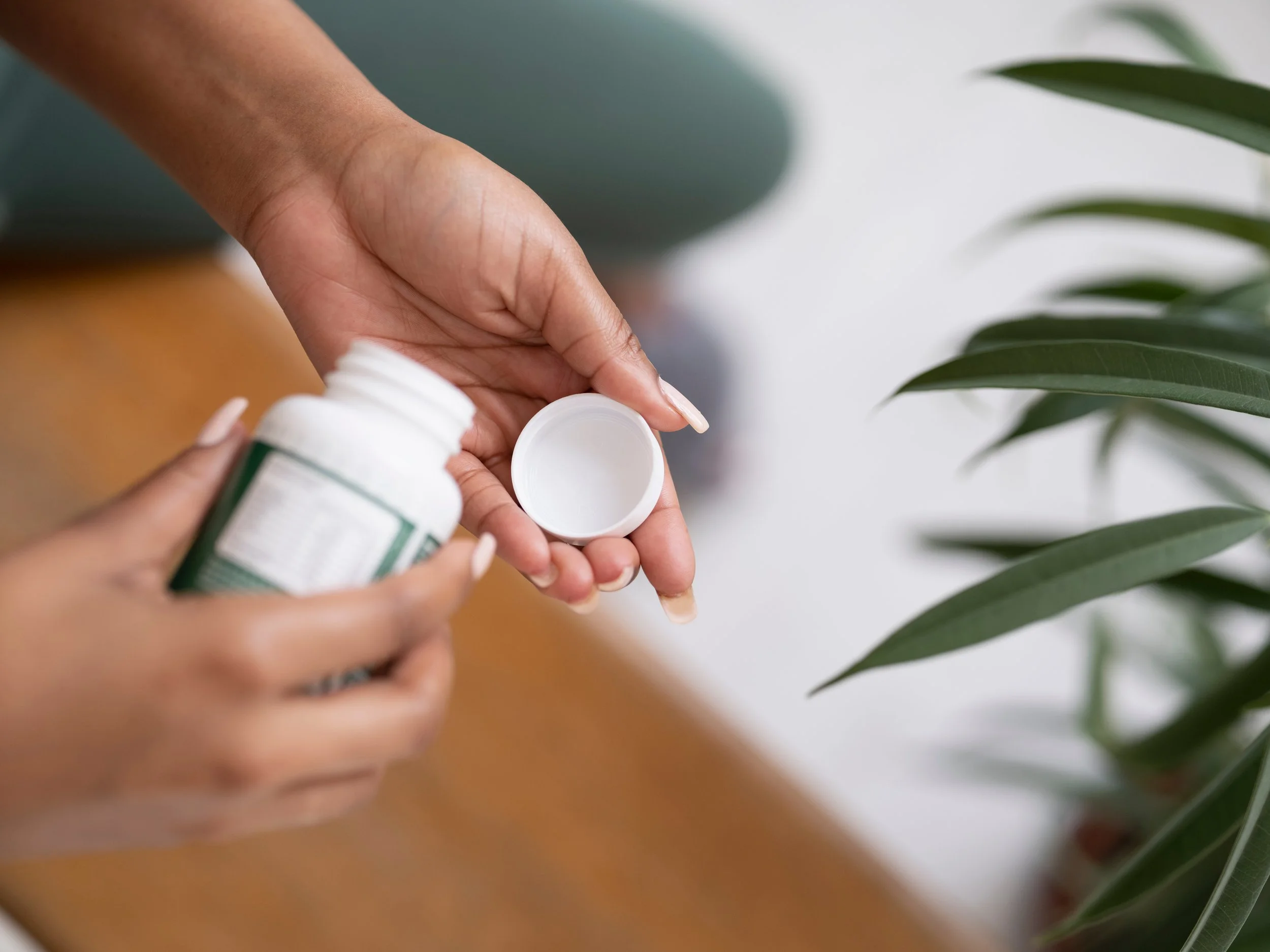 woman pouring some vitamins into her hand