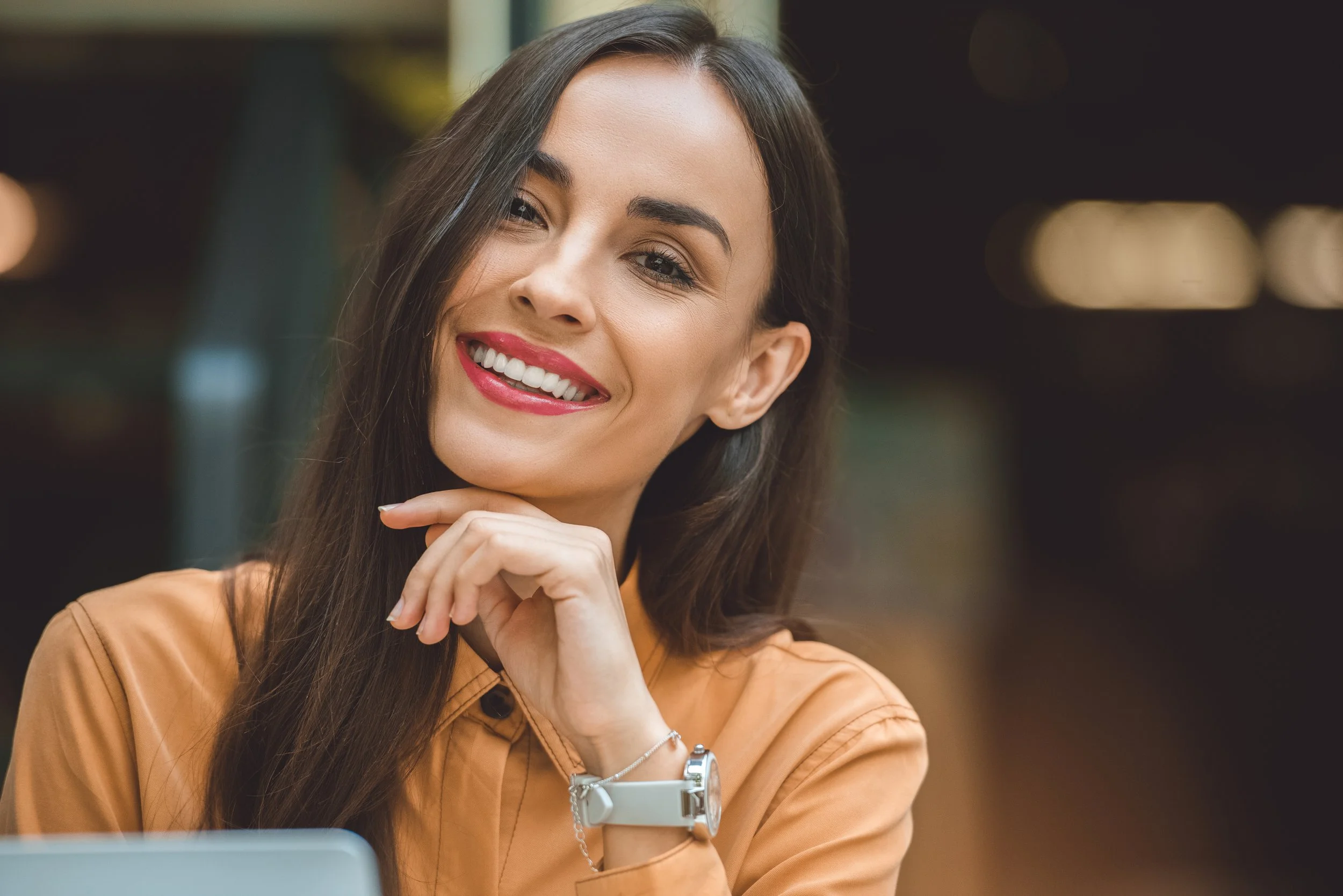 a beautiful woman with dark hair smiling after receiving teeth whitening