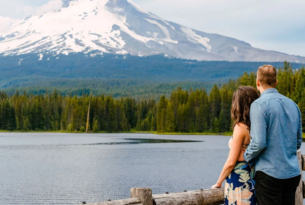 Couple standing together near a mountain lake in the Pacific Northwest, photographed in a calm and natural setting of Lake Trillium, Oregon.