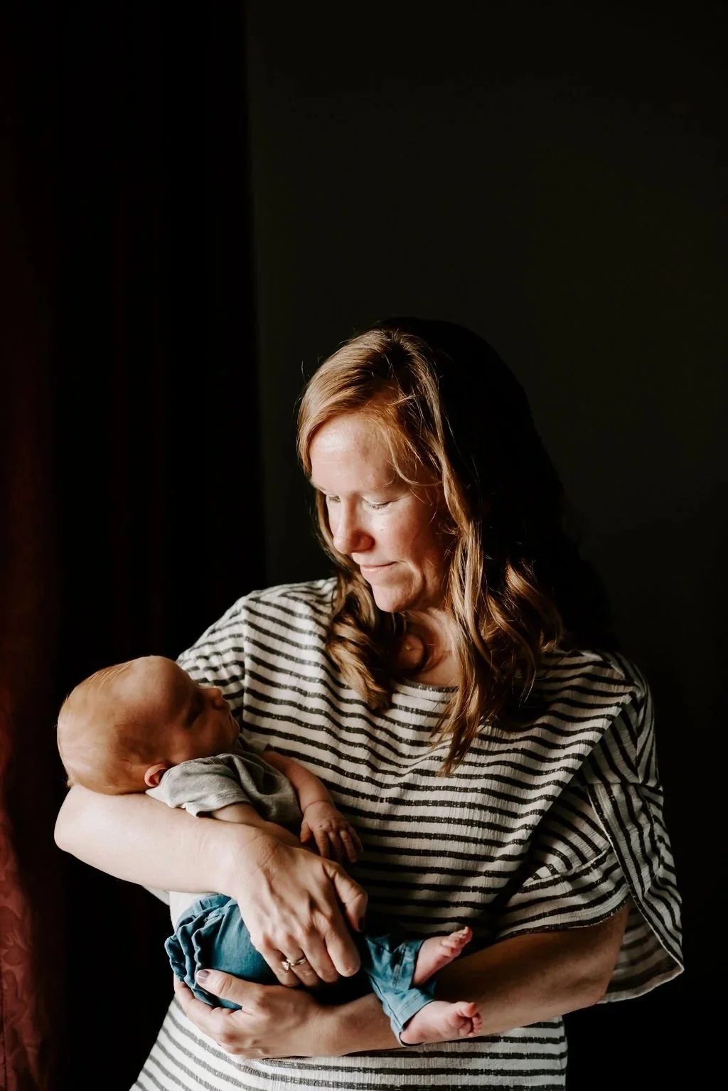 In-home newborn family photo of a mother holding her baby, photographed by a Seattle family photographer