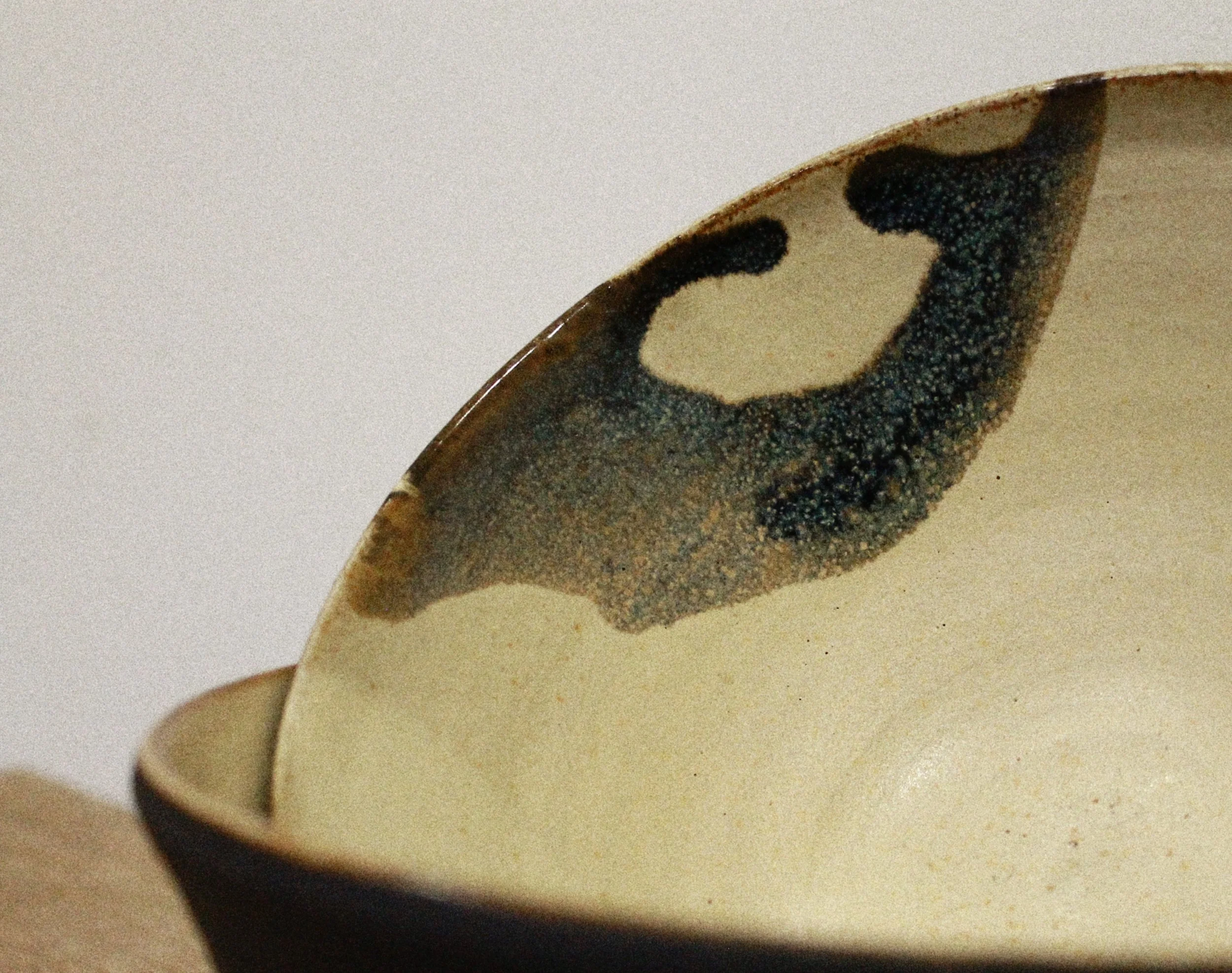Close-up of a ceramic bowl with a decorative, irregular black and beige pattern.