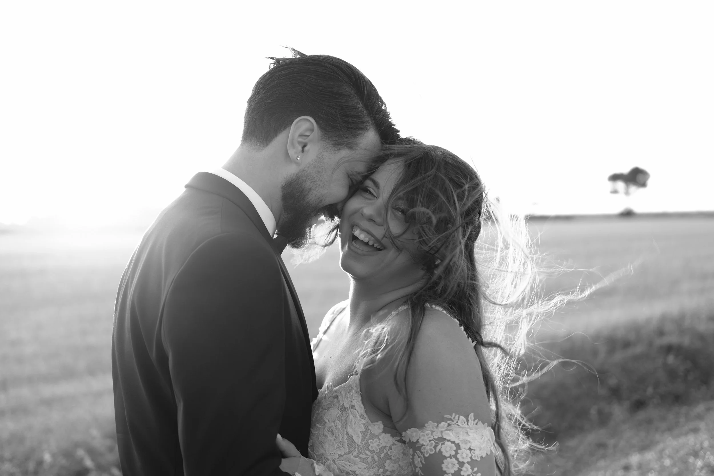 sposi che si abbracciano al tramonto sorridendo bianco e nero, fotografia di matrimonio scattata da Alessandro Carrozzo Weddings in Puglia Taranto