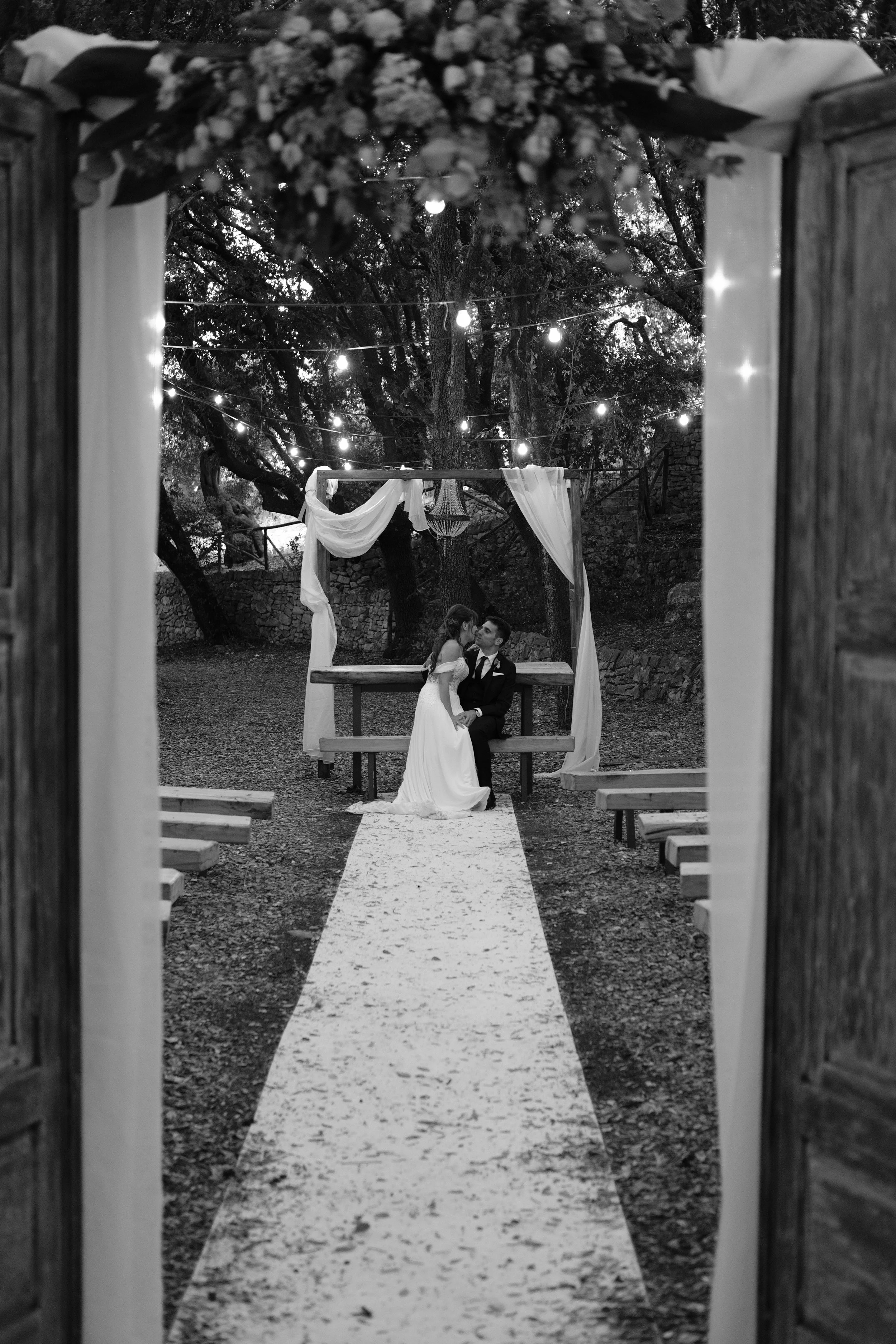 fotografia di due sposi che si baciano in un bosco incorniciati da una porta,fotografia di matrimonio scattata da Alessandro Carrozzo Weddings in