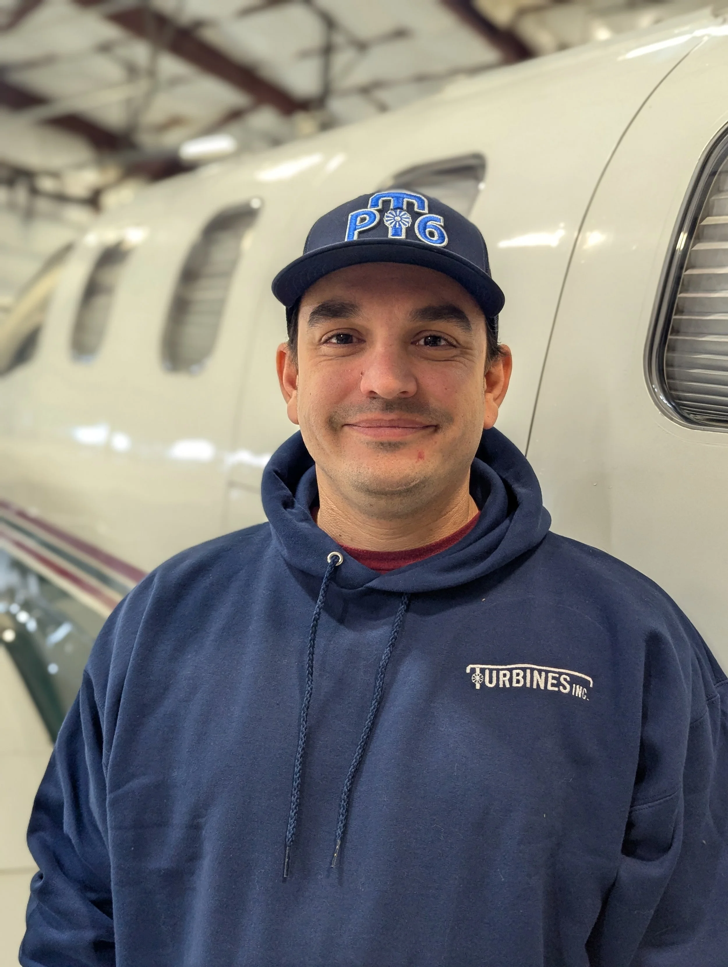 Dustin Wineinger. The hoodie has a logo that reads "Turbines Inc." and the cap has a logo with the text "PT6".