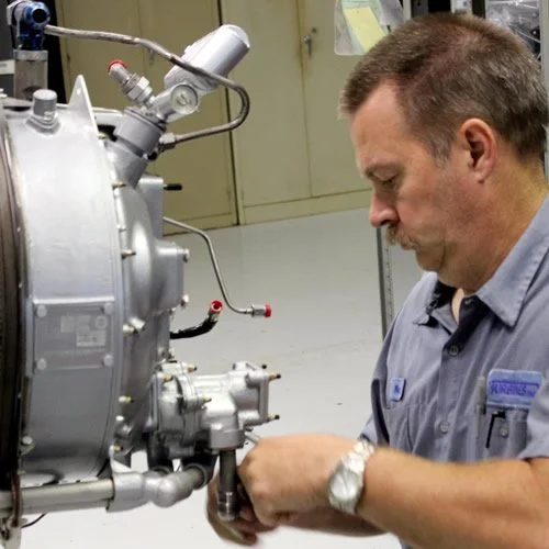 A man working on a overhaul of PT6A engine. Cutting a hot section. Putting Fuel Nozzles in.