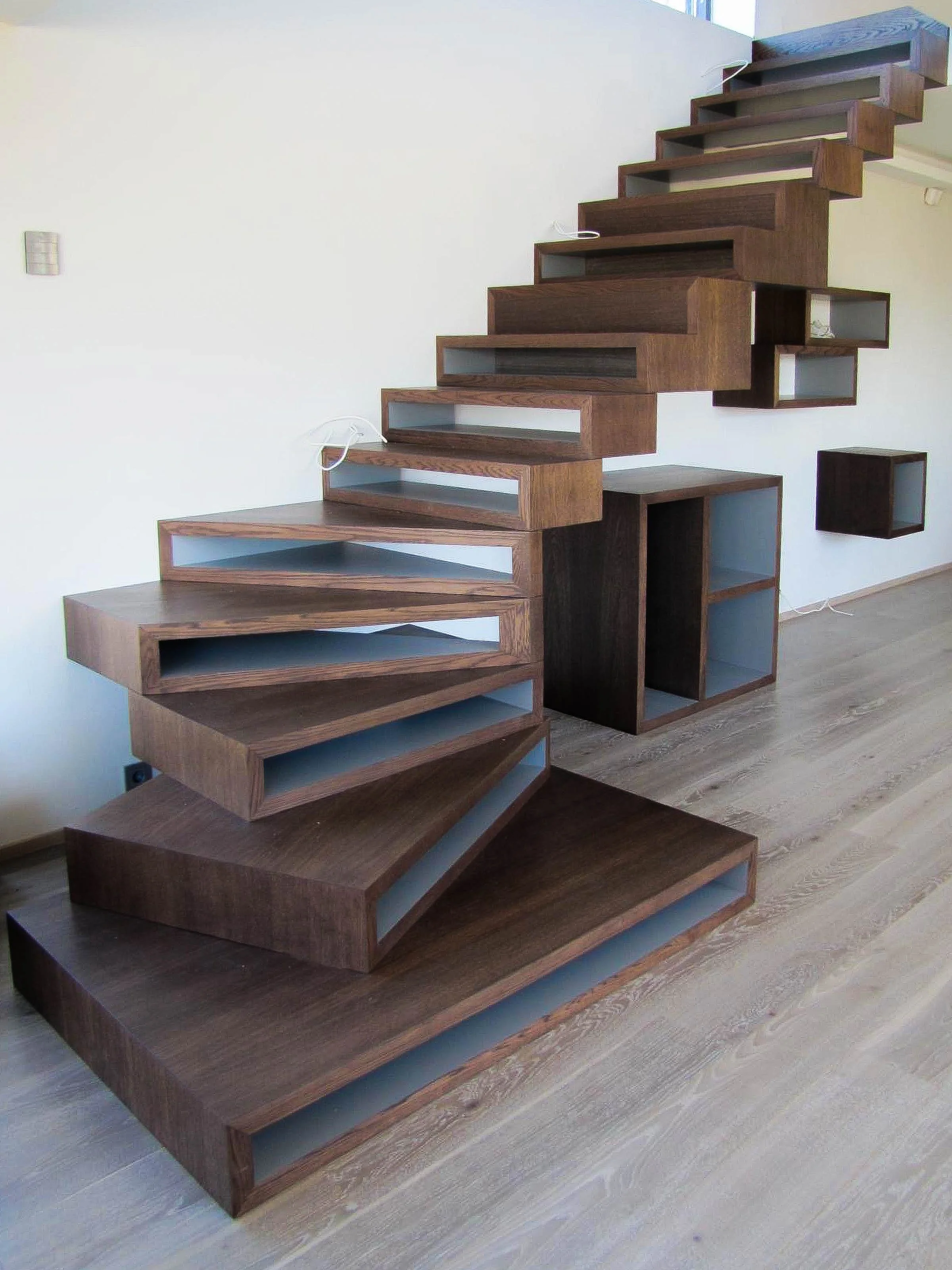 Moodne puidust trepp ainulaadse avatud astmedisainiga ja sisseehitatud riiulitega.