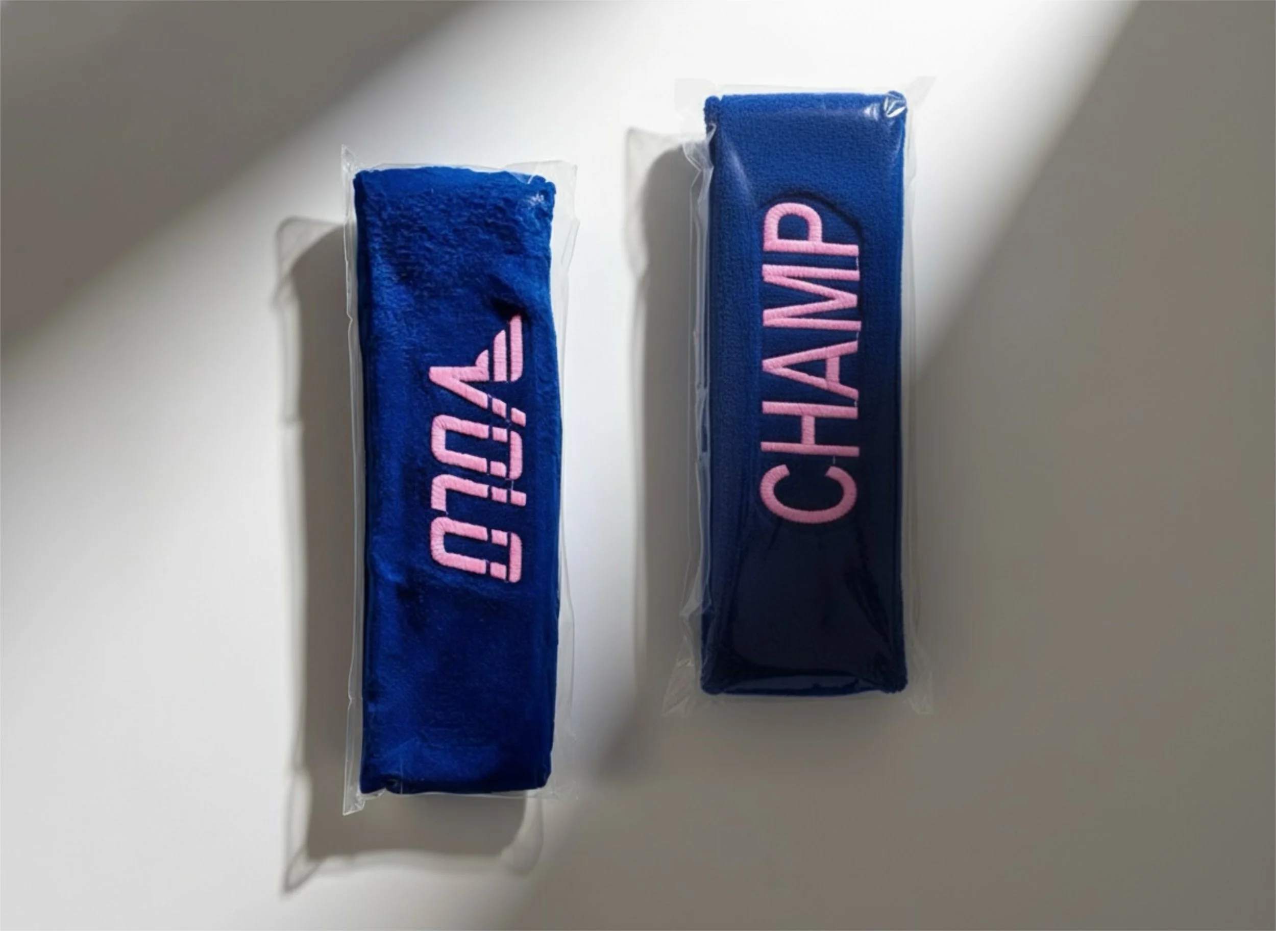 Two blue headbands, one with pink embroidered 