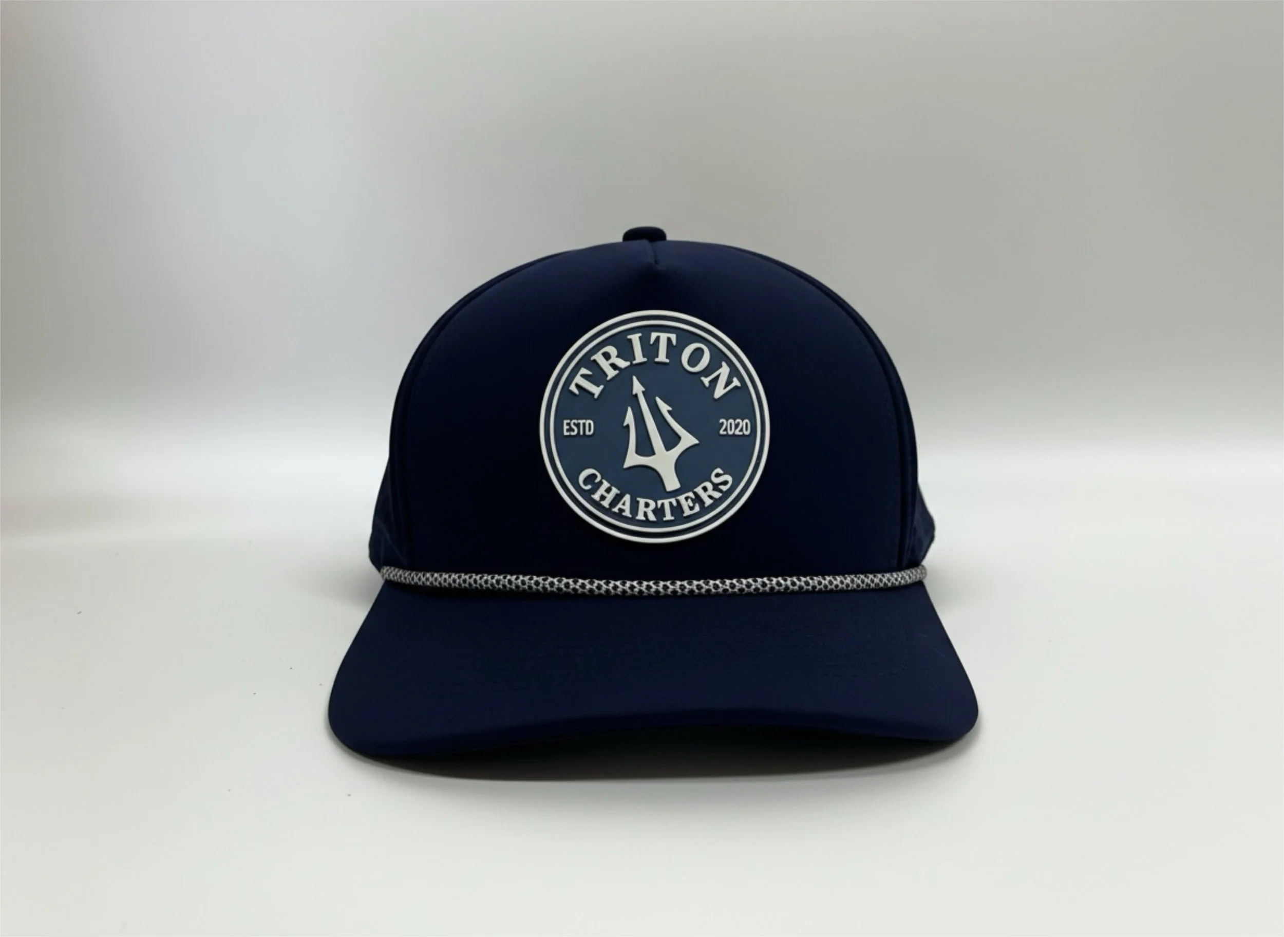 Navy blue baseball cap with a circular logo reading 'TRITON CHARTERS ESTD 2020' and a trident symbol, set against a plain white background.