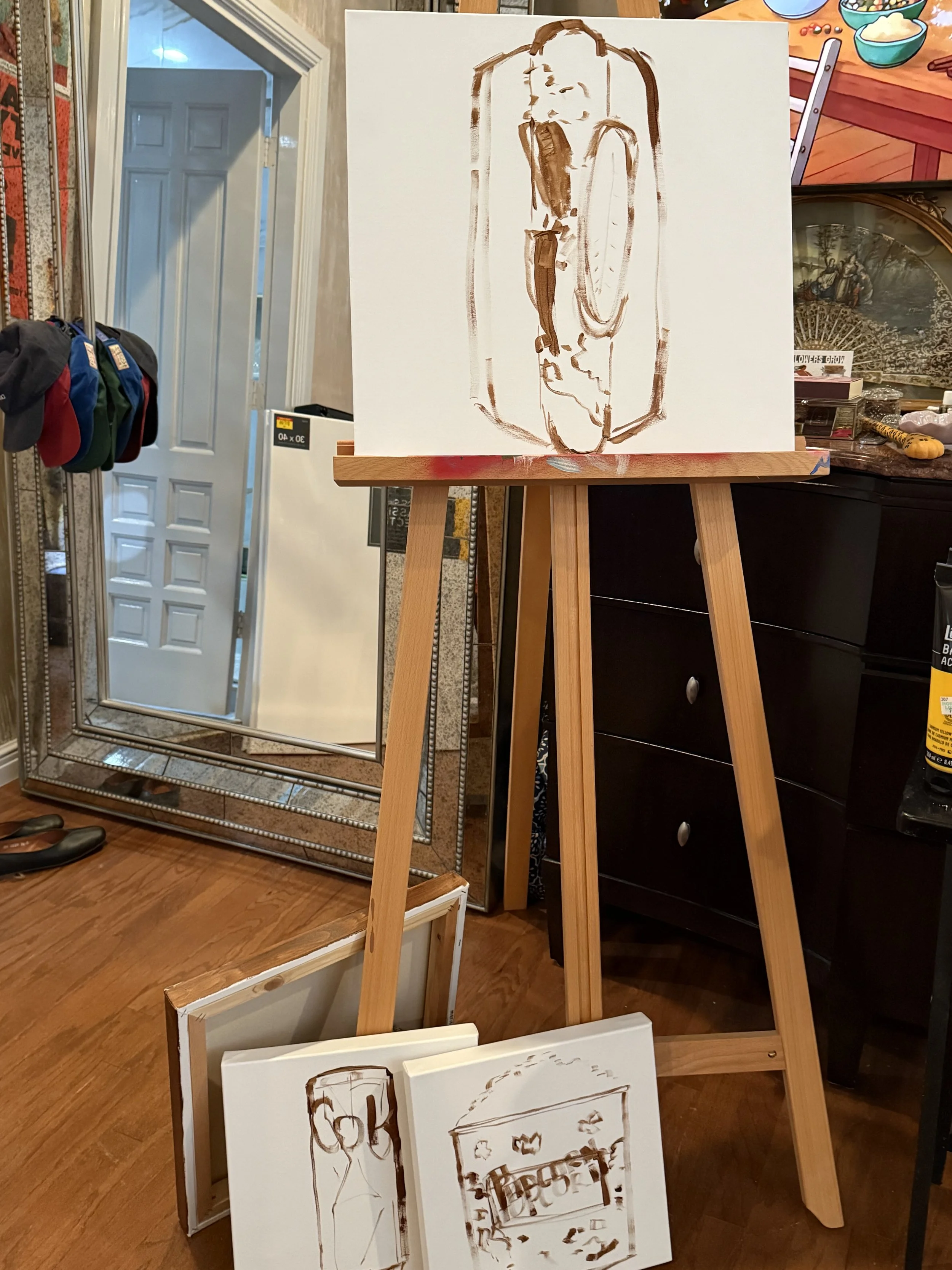 A painting of a hot dog with mustard on a stand, surrounded by framed artwork and mirrors in a room.