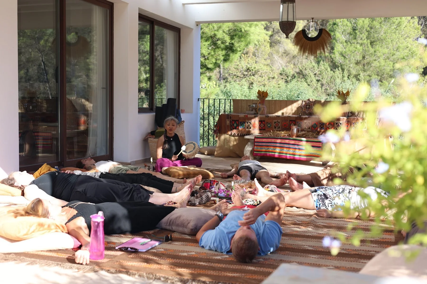 Participants resting on mats on a shaded terrace during a previous Ibiza retreat.