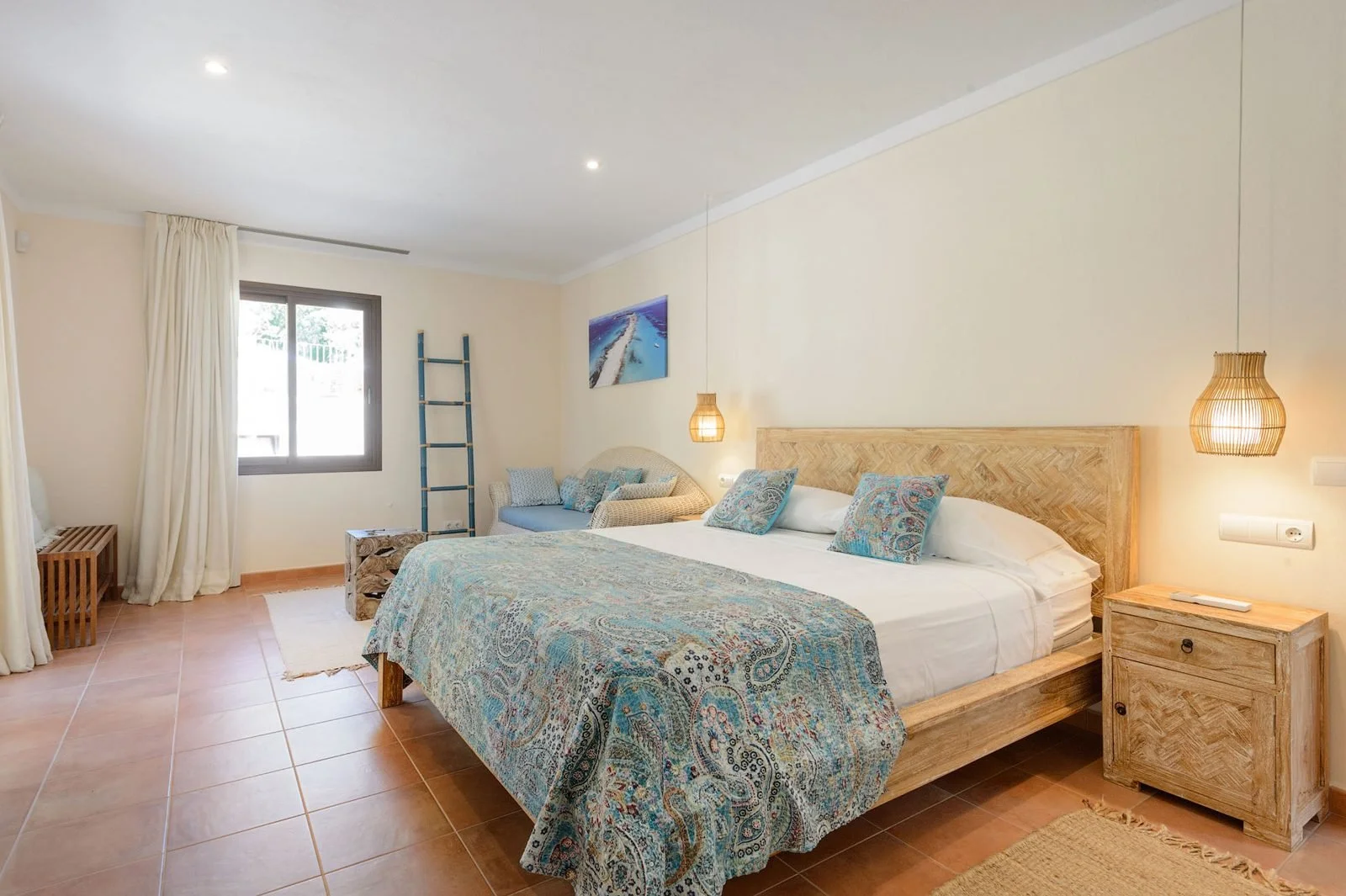 Example of a double bedroom at our Ibiza retreat villa, with blue textiles and natural light.