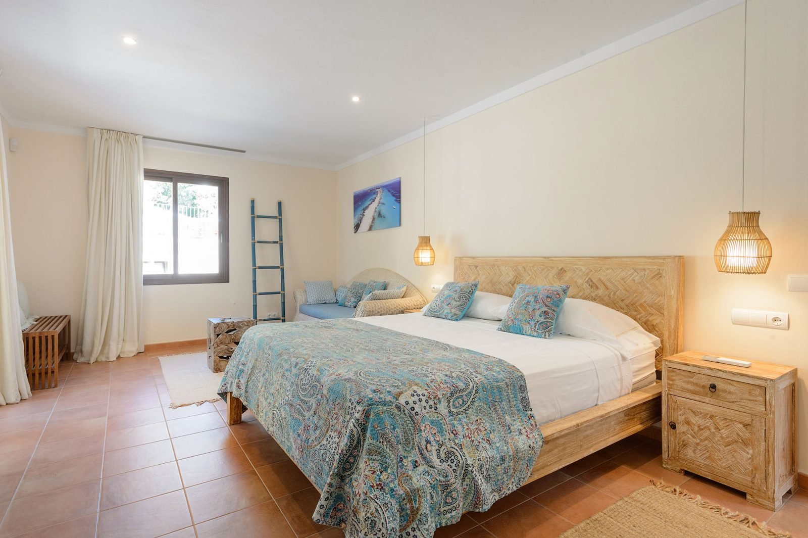Example of a double bedroom at our Ibiza retreat villa, with blue textiles and natural light.