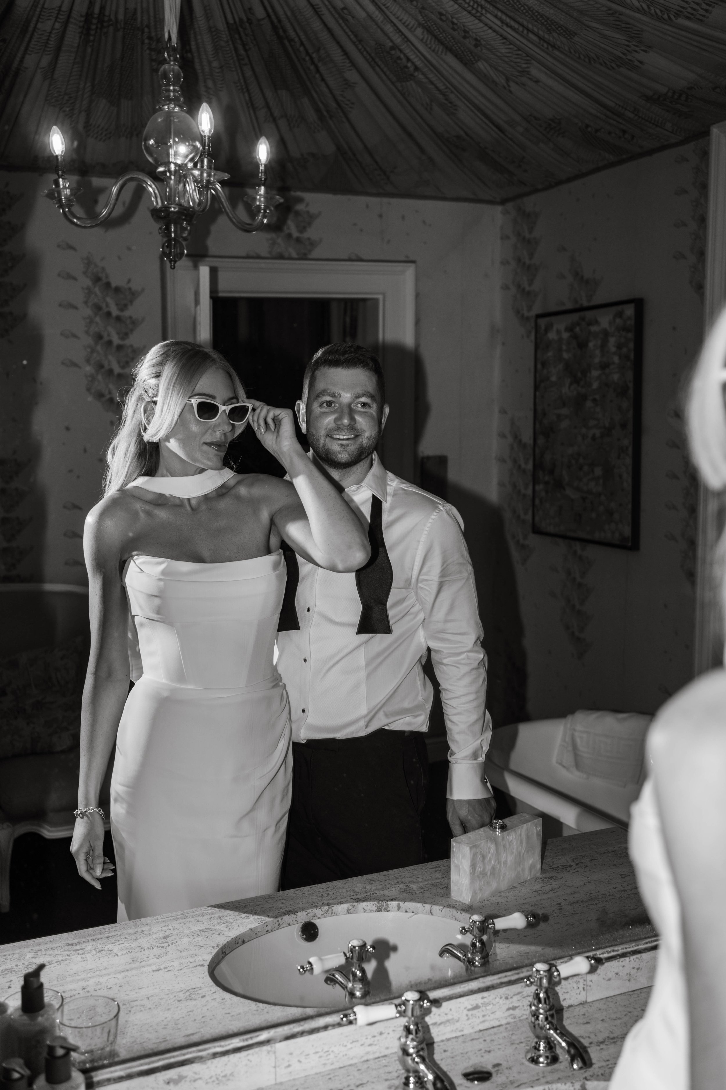 Outfit change for bride and groom, vintage bathroom in background at Askham Hall