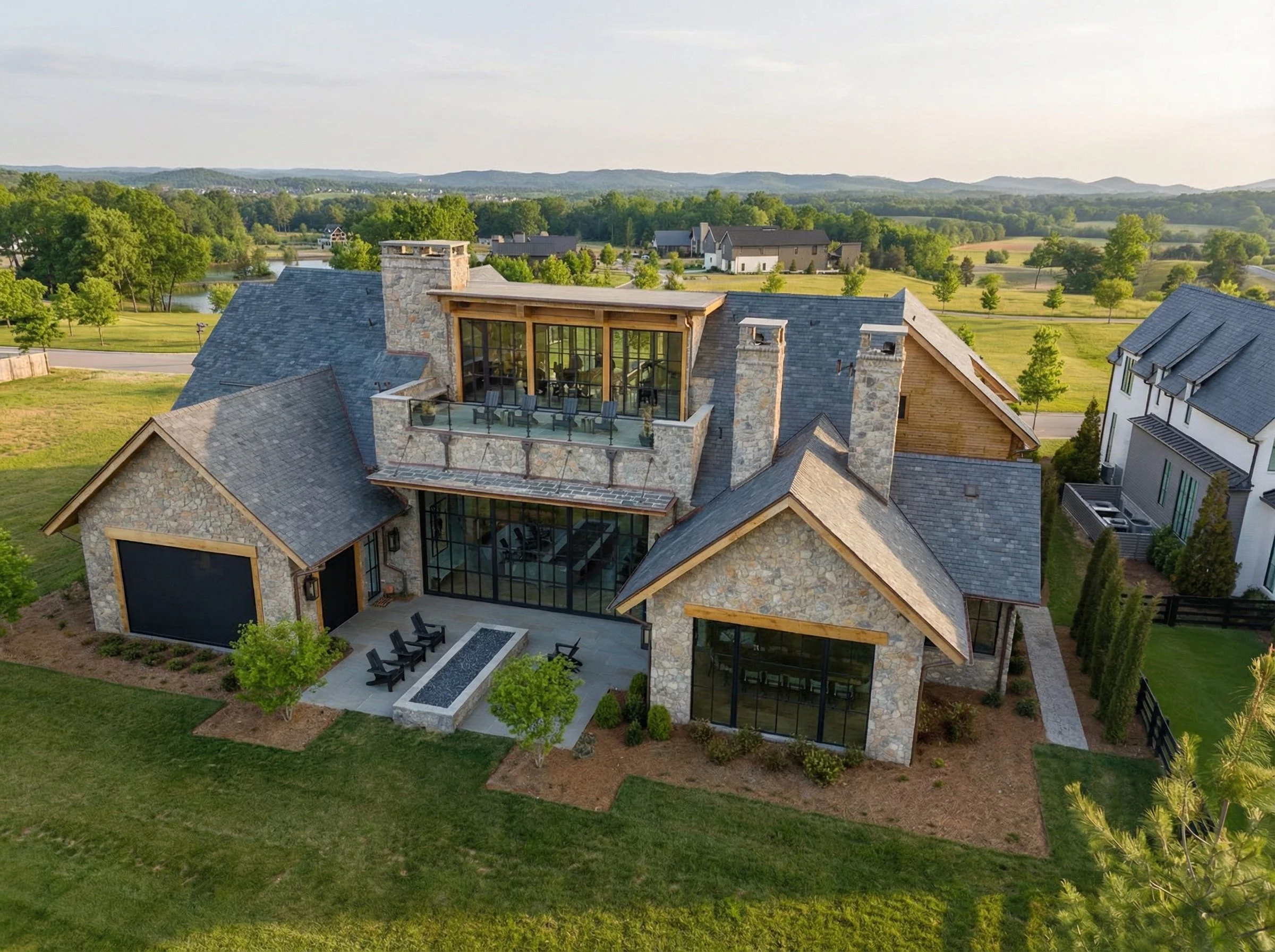 Luxury home in Middle Tennessee with stone exterior, balcony, and spacious outdoor living area.