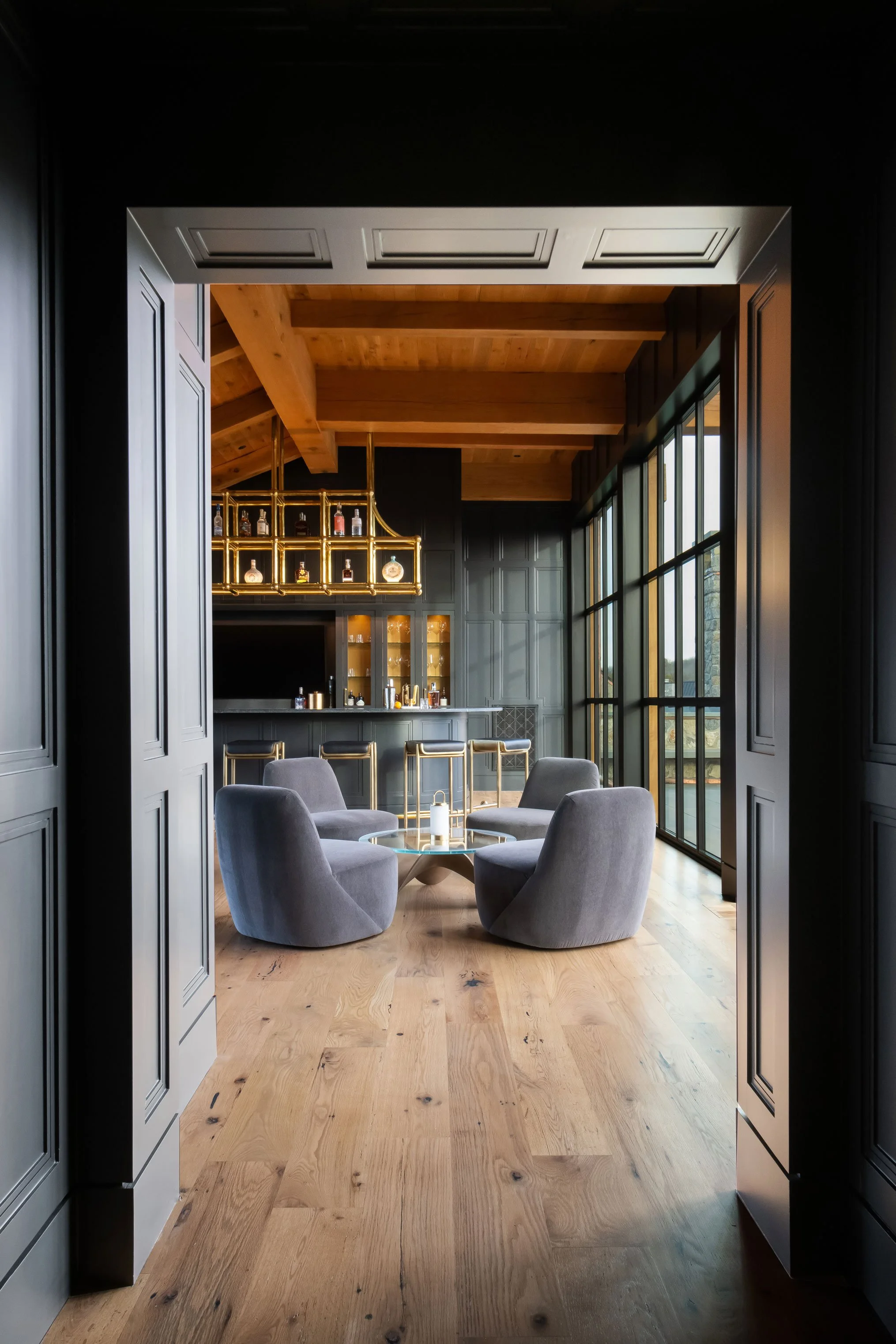 Luxury bar and lounge area in custom home Nashville with wood floors, statement lighting, and modern furnishings.