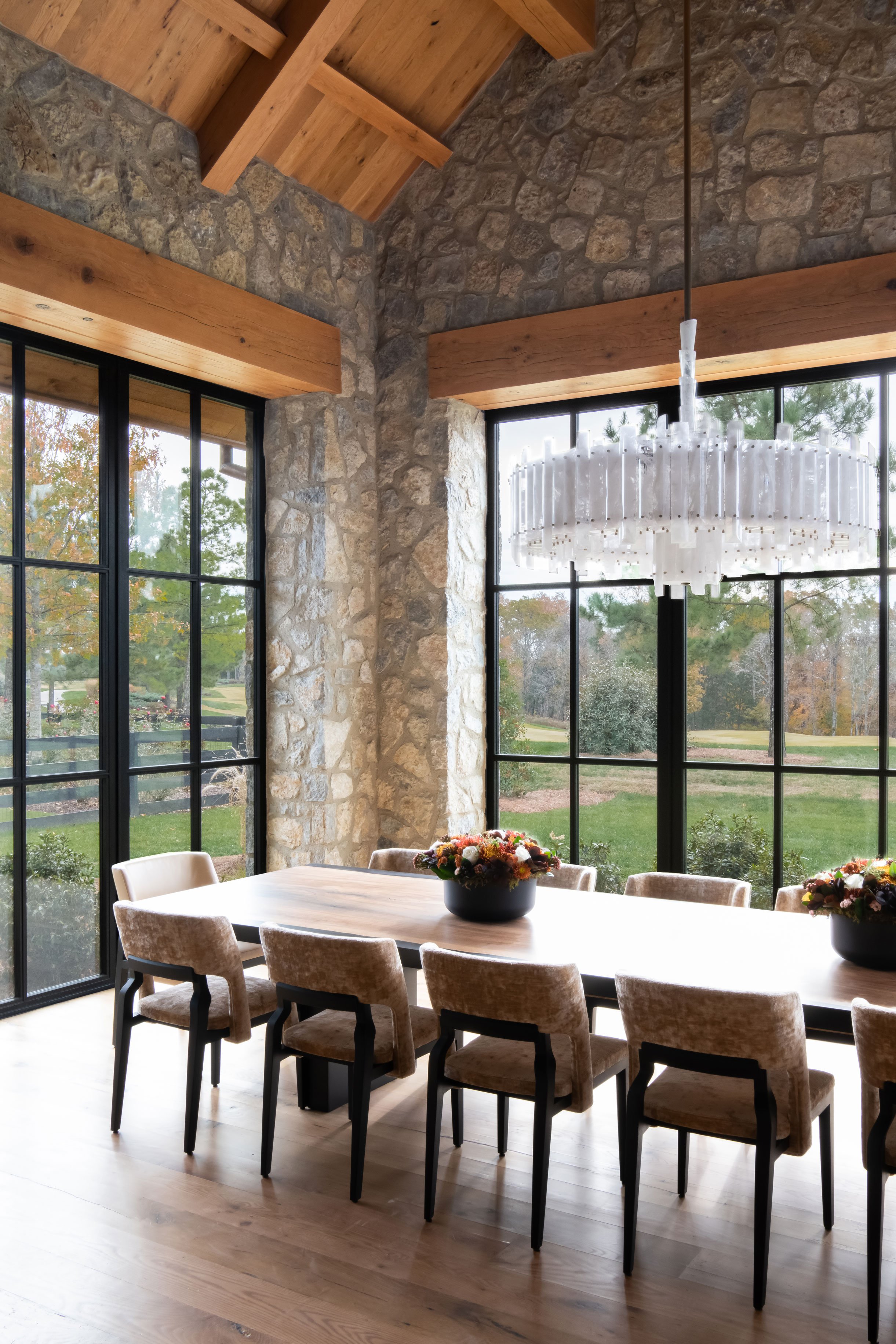 Luxury dining room with stone walls and expansive windows. Custom home Nashville.