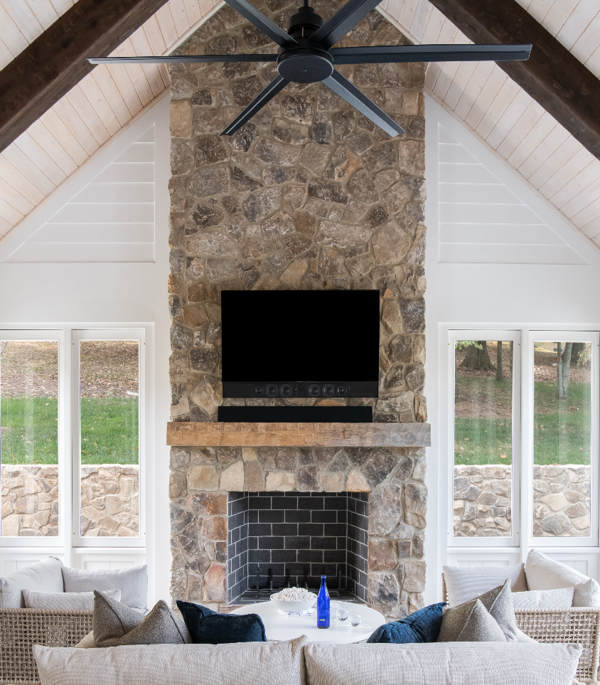 Stone fireplace, vaulted ceiling, and cozy seating area in a custom home by luxury home builder Nashville.