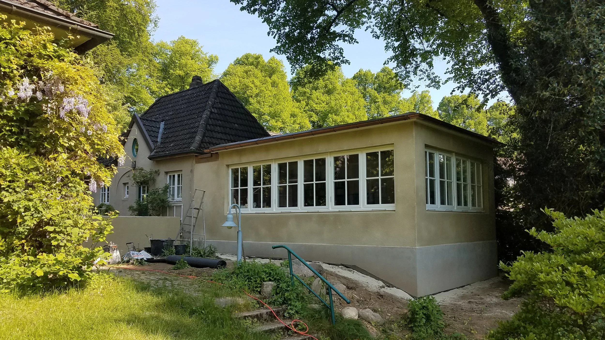 frisch verputzter Anbau an ein denkmalgeschuetztes Haus