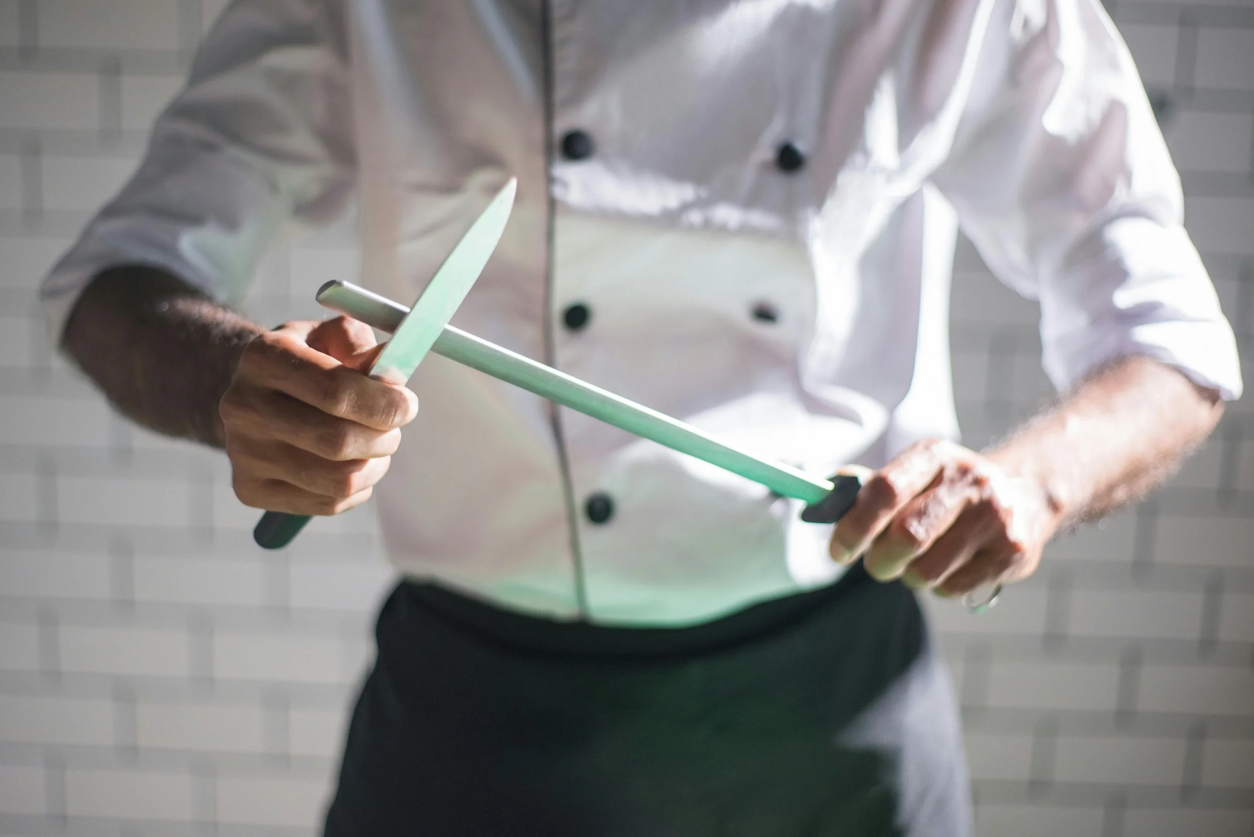 Chef in white uniform holding a kitchen knife