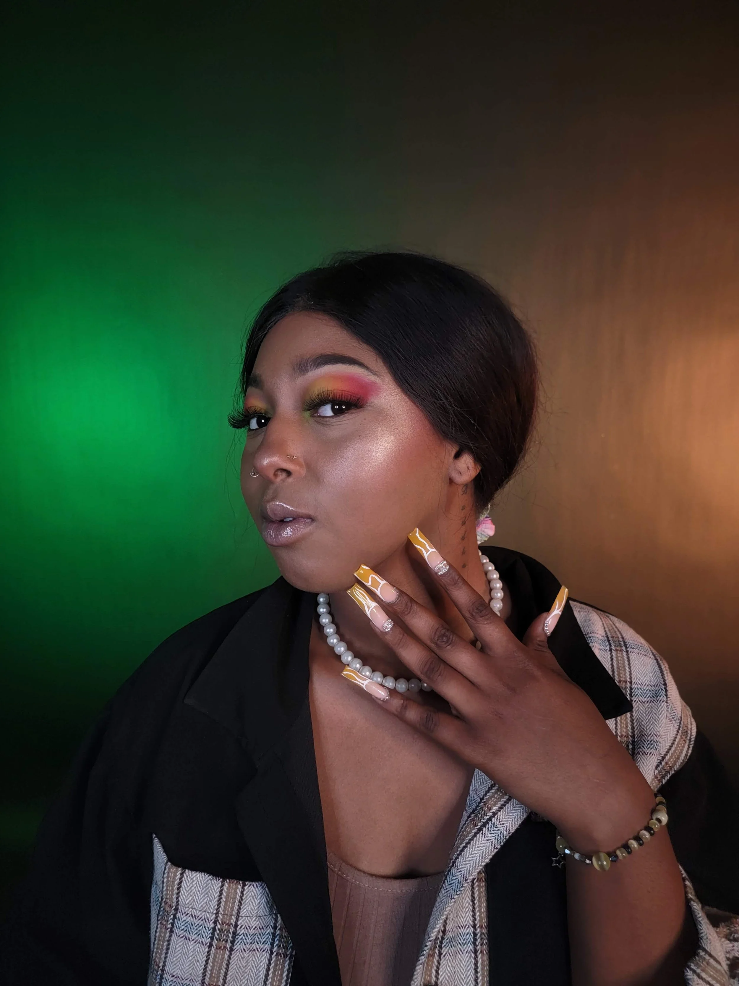 Close-up of a High-fashion makeup look featuring graphic neon eyeshadow and high-gloss skin for an editorial photoshoot; featuring model, Lauren.