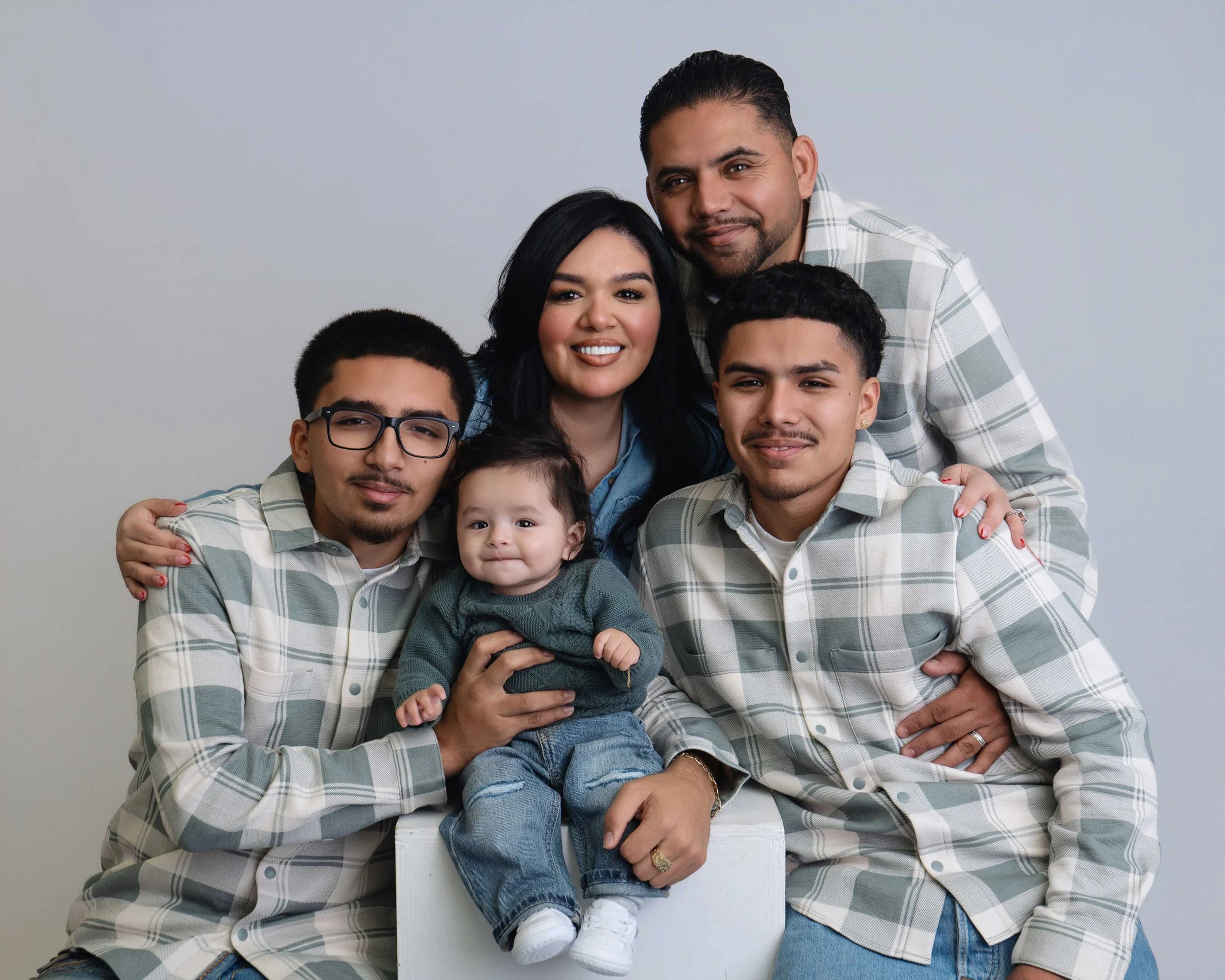 Family of five posed against a white studio backdrop during a professional family photography session in Modesto, California.