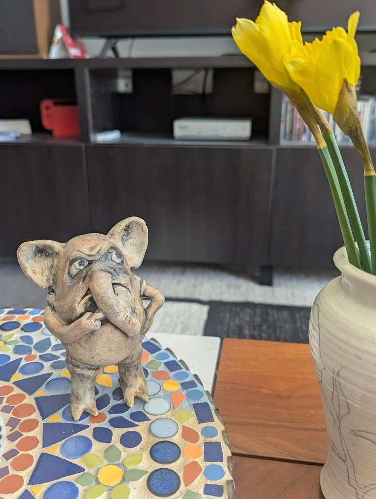 Elephantesque sculpture giving a judging look at some flowers