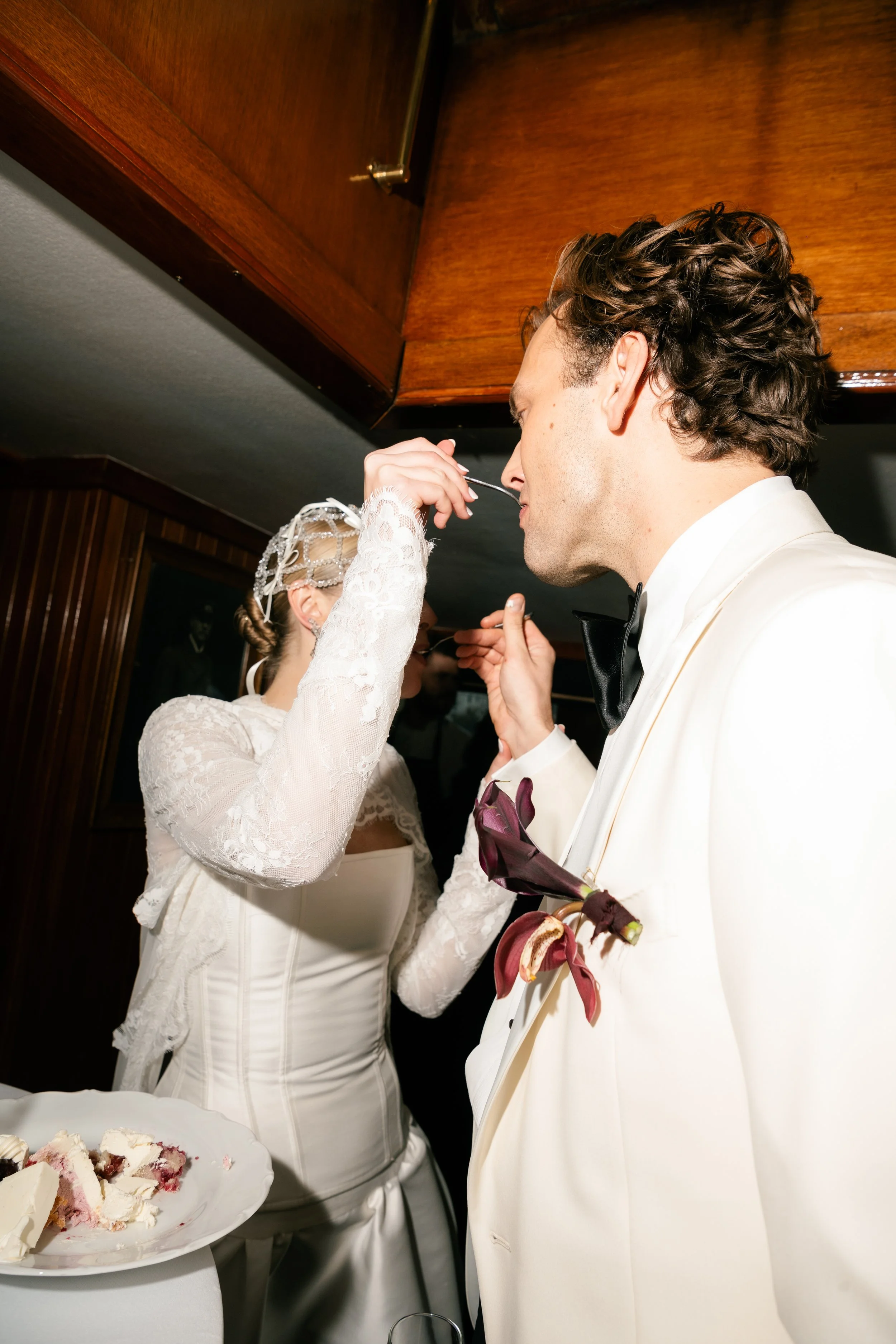 A bride and groom feed each other wedding cake.