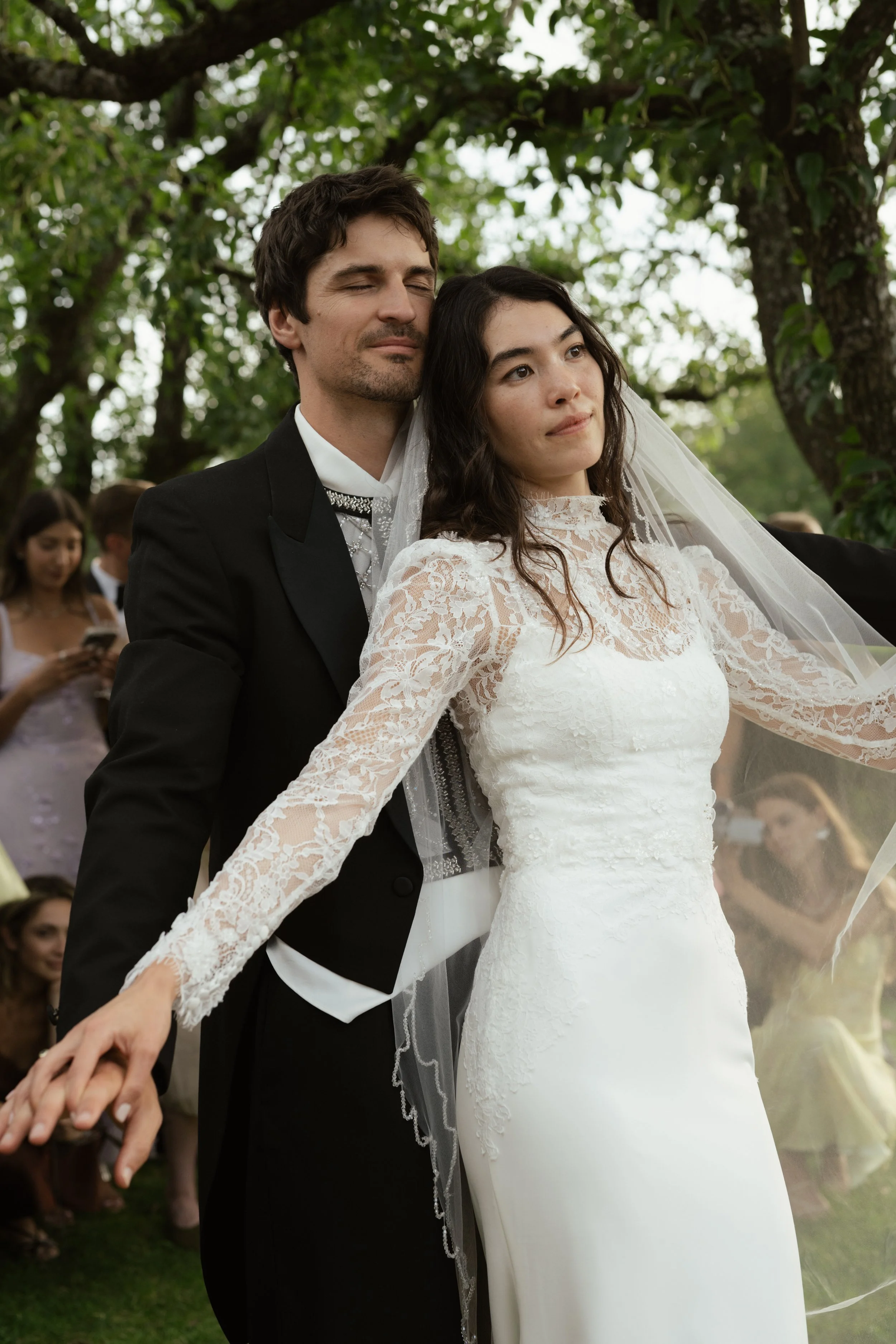 Bride and groom sharing a dance outdoors surrounded by guests during a wedding ceremony.
