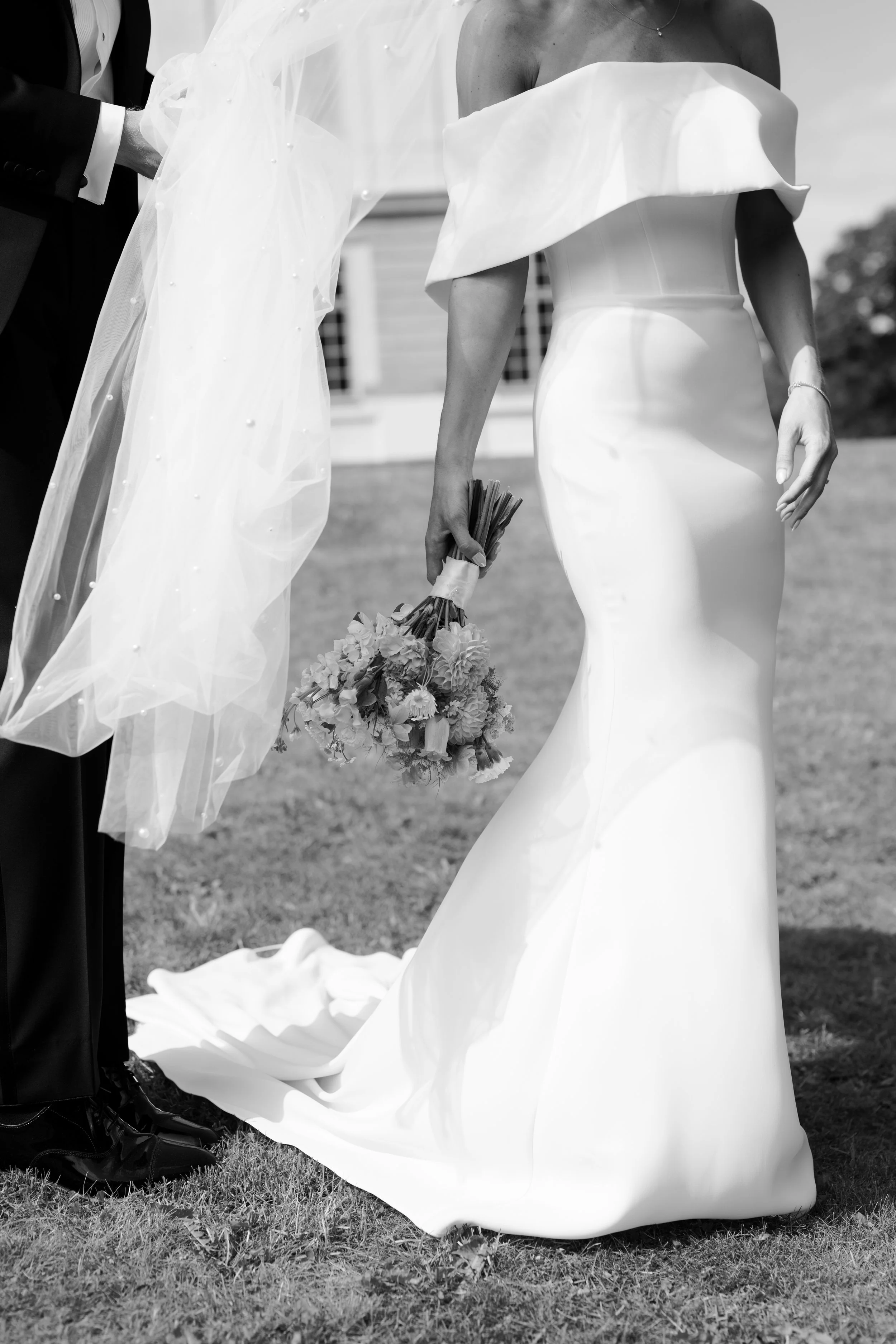 Close-up of a bride in a strapless wedding gown holding a bouquet during a wedding ceremony.