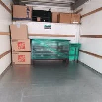 Empty storage unit with cardboard boxes and plastic storage containers