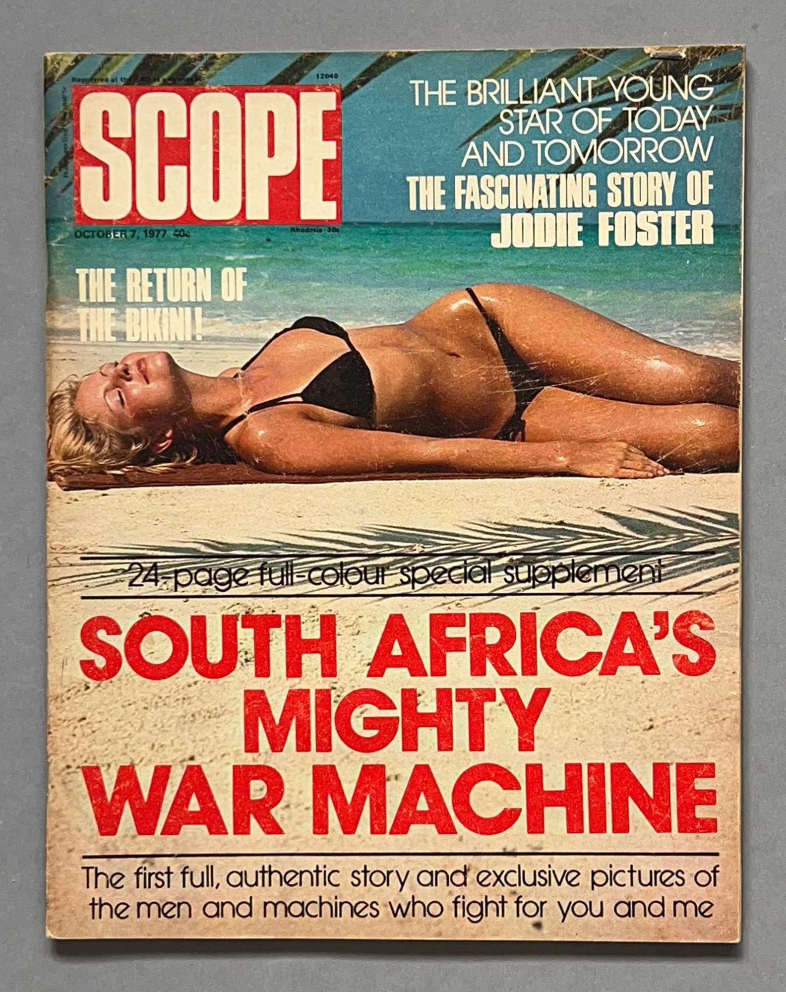 Magazine cover of Scope from October 7, 1977, featuring a woman in a black bikini lying on a beach with the ocean in the background. Text highlights include stories about Jodie Foster, bikinis, and South Africa's military history.