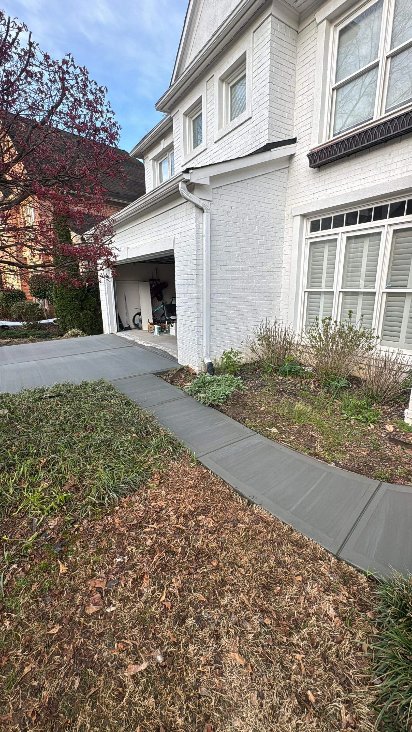 Freshly poured and finished custom curved concrete walkway leading to a residential home entrance.