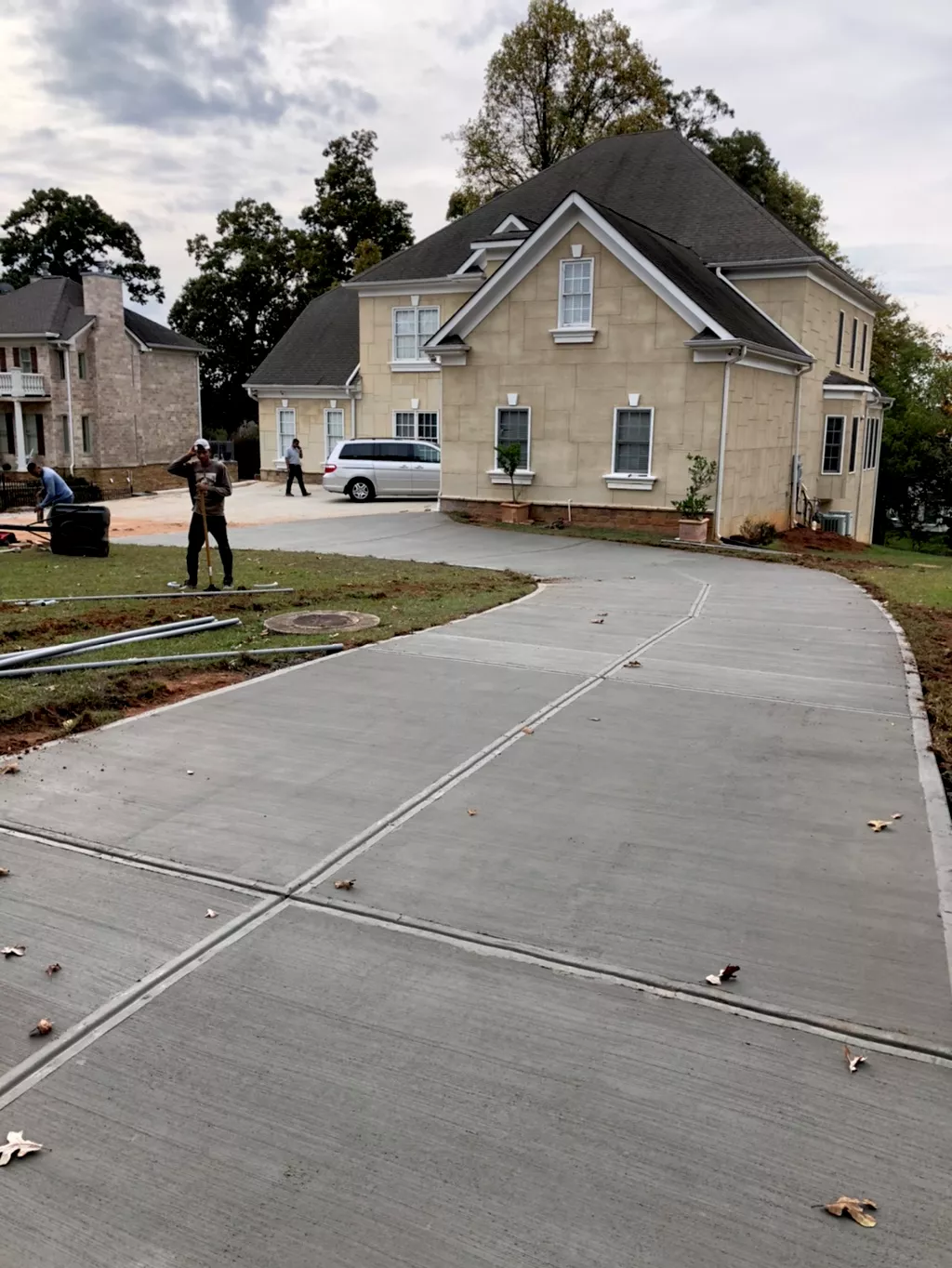 Concrete contractor meticulously spreading wet concrete for a narrow side yard walkway in Atlanta.
