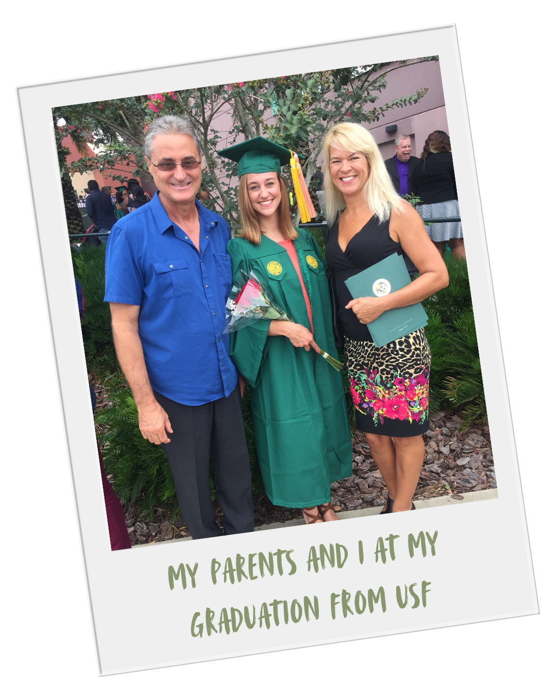 A young woman in a green graduation gown and cap holding a bouquet of flowers, standing between her parents at her graduation ceremony, outdoors with greenery and people in the background.