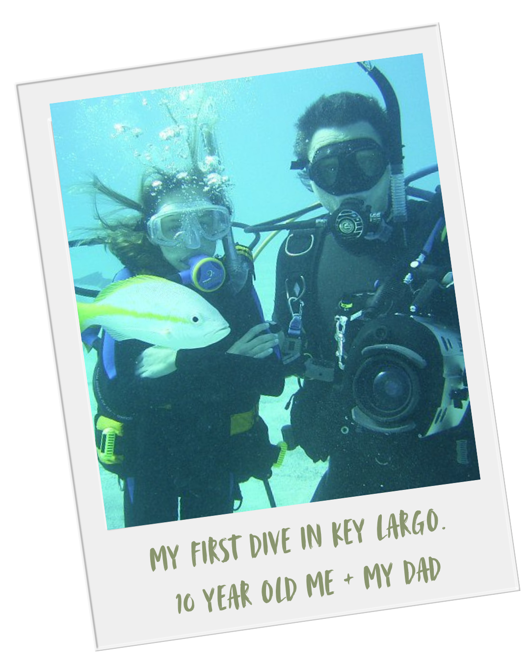 A man and a young girl scuba diving in Key Largo, with a fish. Both are wearing scuba diving gear. The photo resembles a Polaroid with handwritten-style text that reads, "My first dive in Key Largo. 10 year old me + my dad."