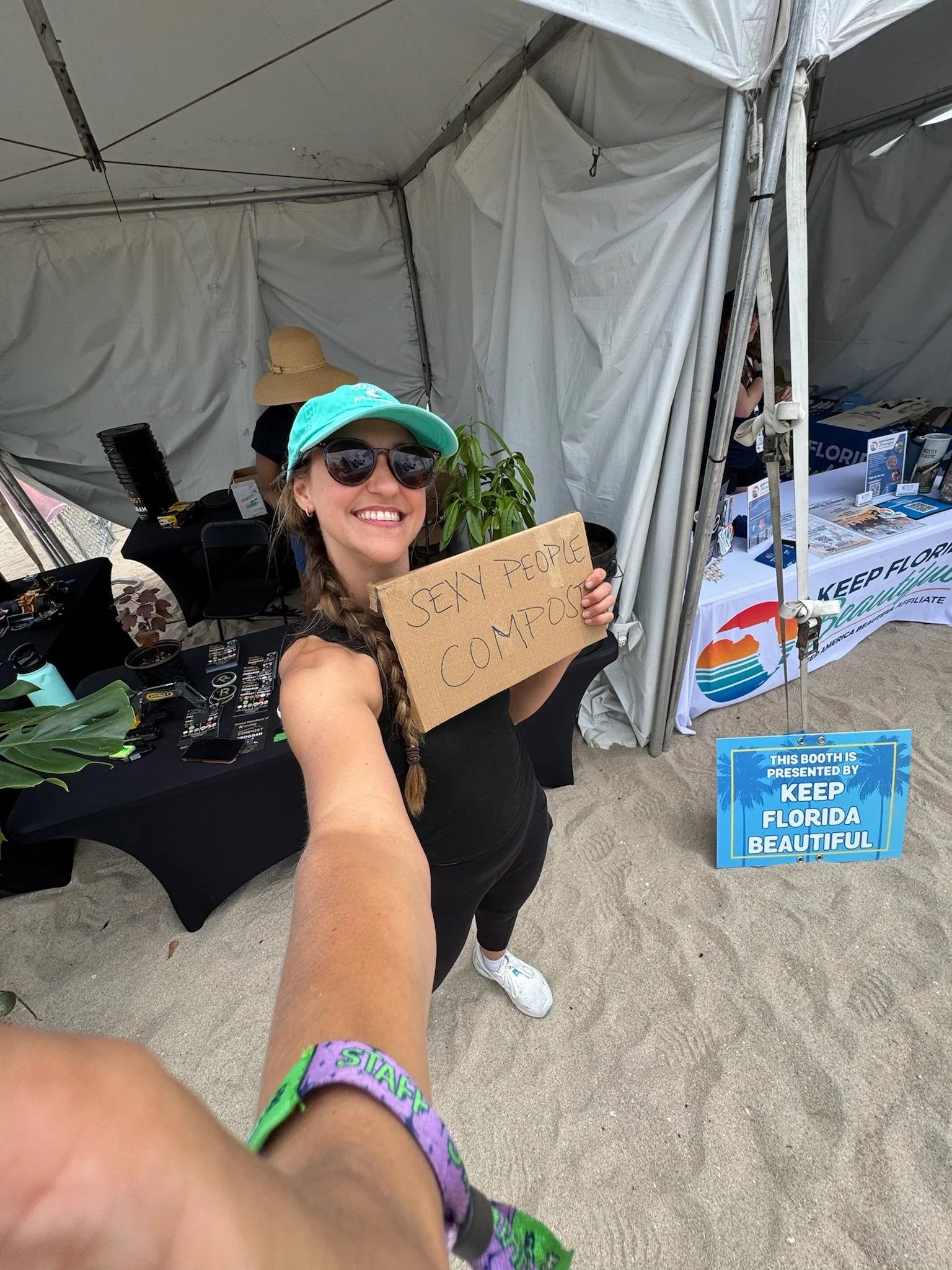 Woman holds up "composting is sexy" sign.