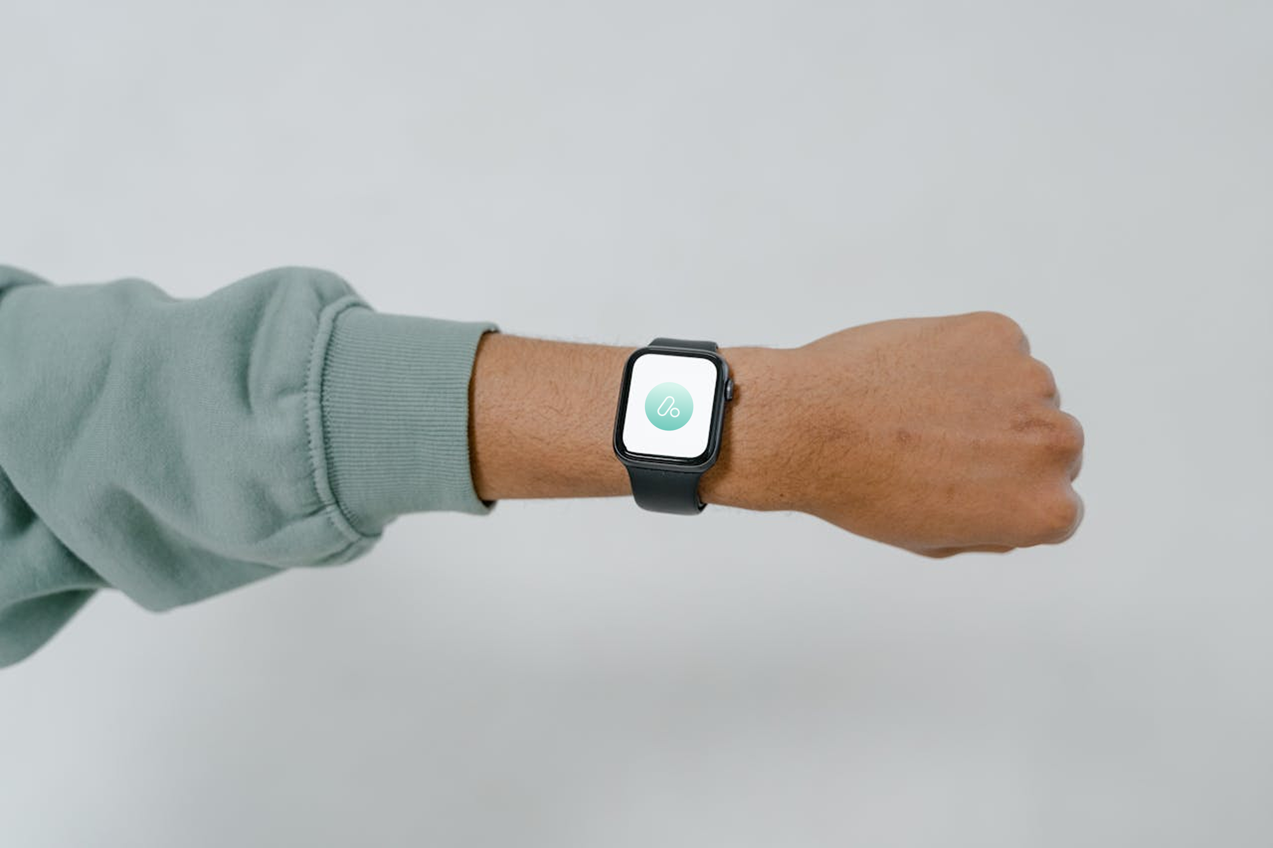 A person's wrist wearing a smartwatch displaying a hydration app icon on a light background.