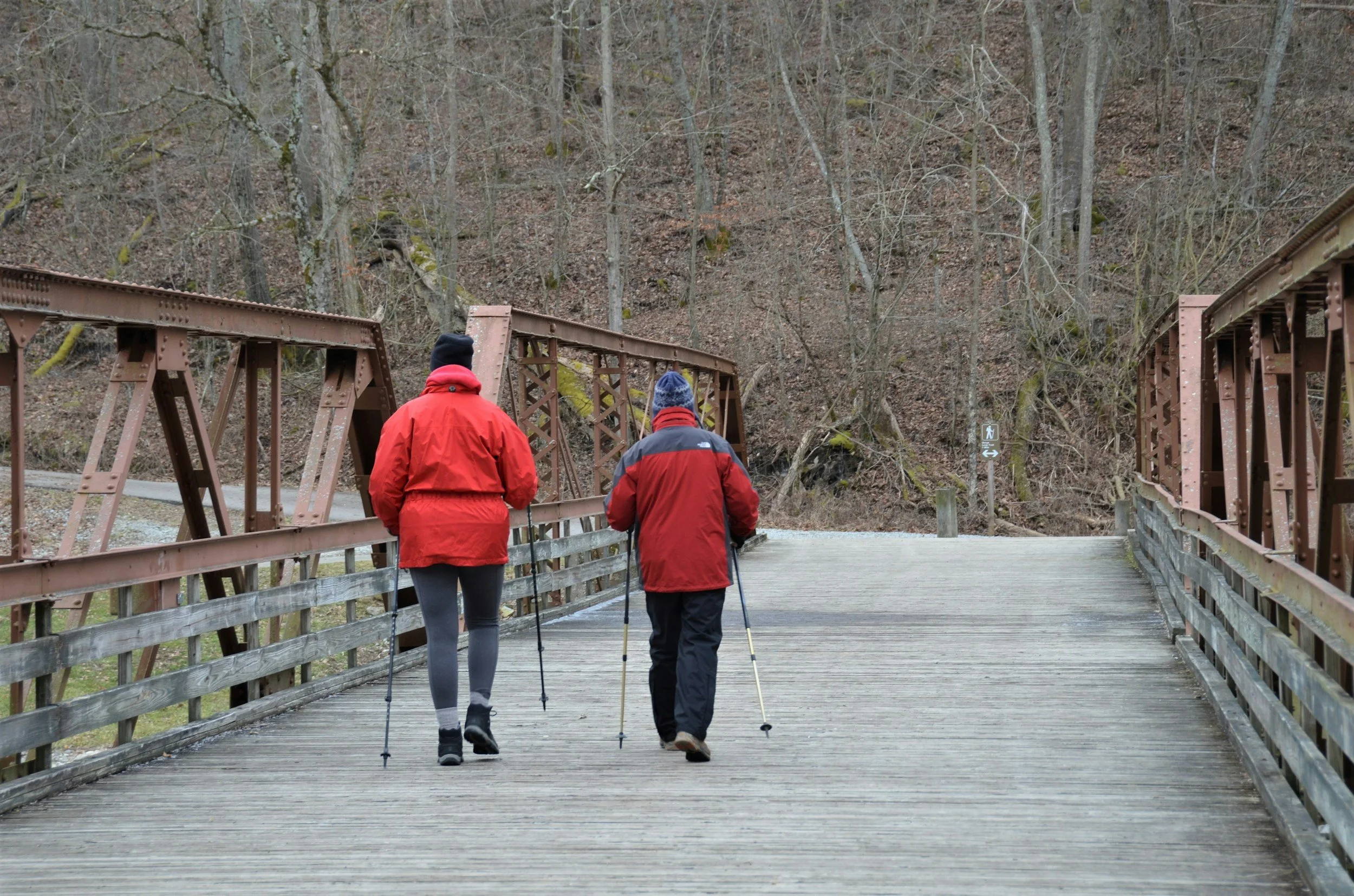 Two elderly patients going on a hike over a wooden bridge