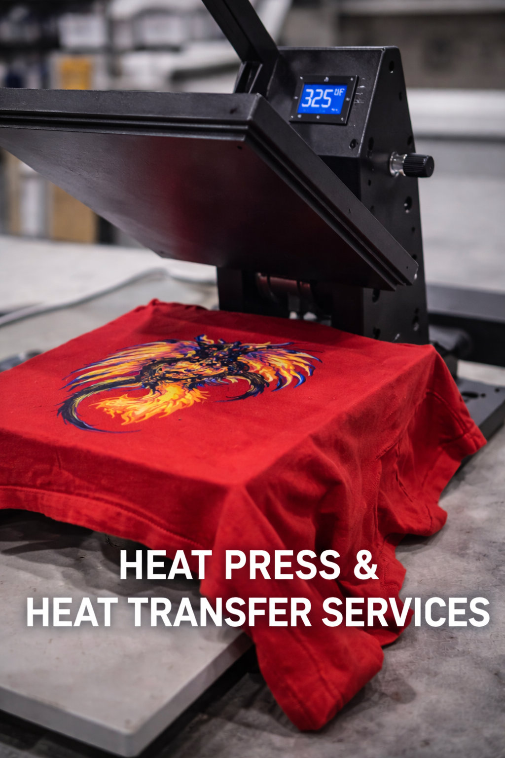A heat press machine printing a colorful fiery dragon design onto a red fabric shirt.