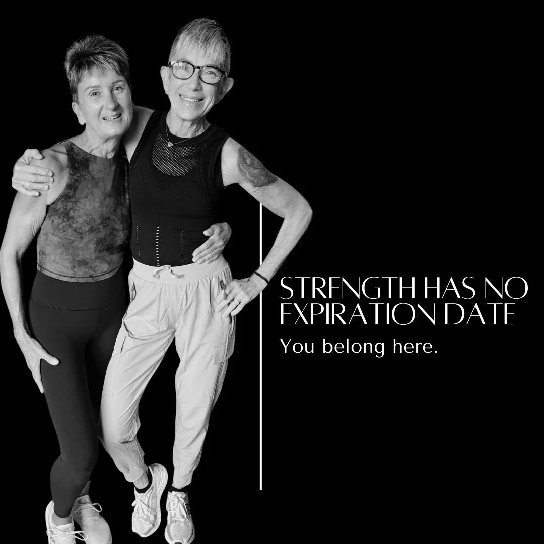 Two elderly women posing together, smiling, against a black background with white text that reads, 'Strength has no expiration date. You belong here.'