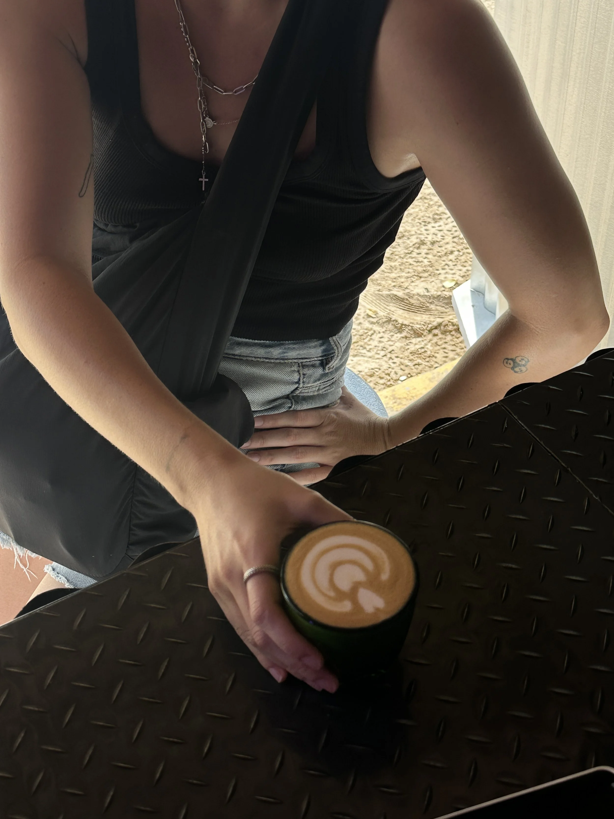 Latte con latte en manos de una clienta a punto de tomarlo