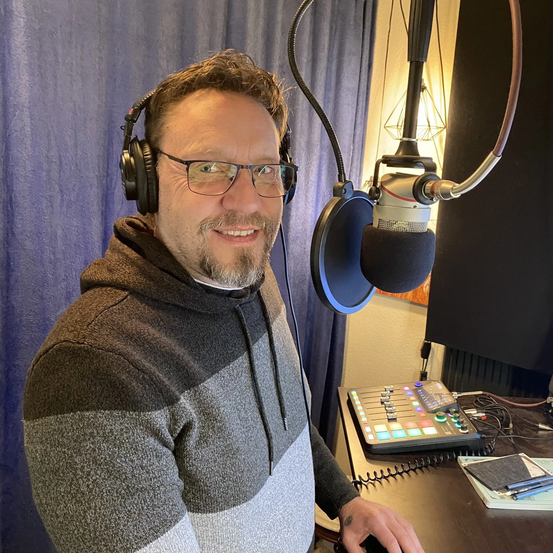 JJ in his studio with headphones on at the mike