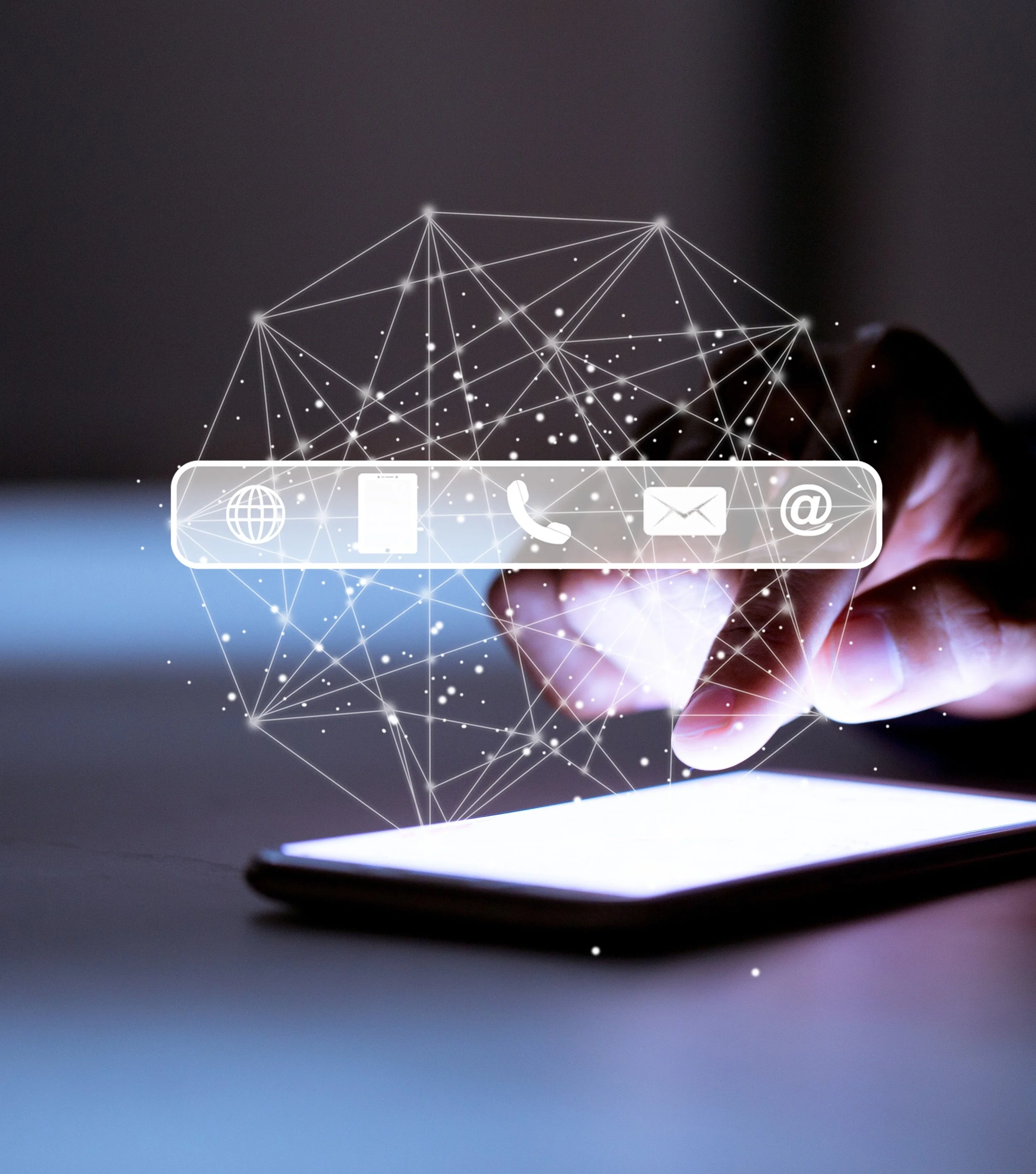 A person touching a smartphone screen with a holographic overlay of social media icons, including a globe, a phone, a mail, and an at symbol, connected by a network of lines and dots.