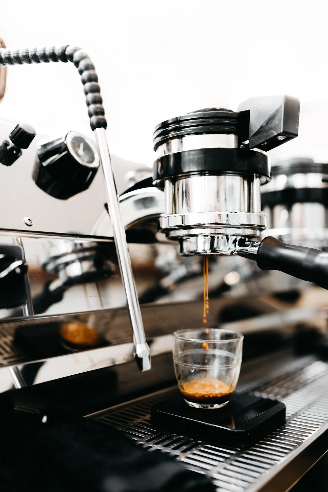 Espresso machine brewing coffee into a glass cup.